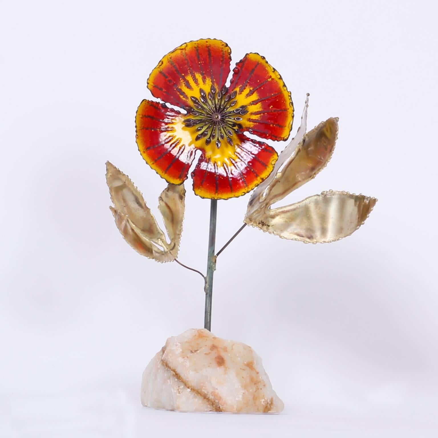 Sprouting from a block of quartz; a metal stem with two brass flowers cut to a Brutalist form. The flower to bloom forever has four red and yellow enamel pedals with life like stamen in the center. Will add a good vibe to any interior. Signed C.