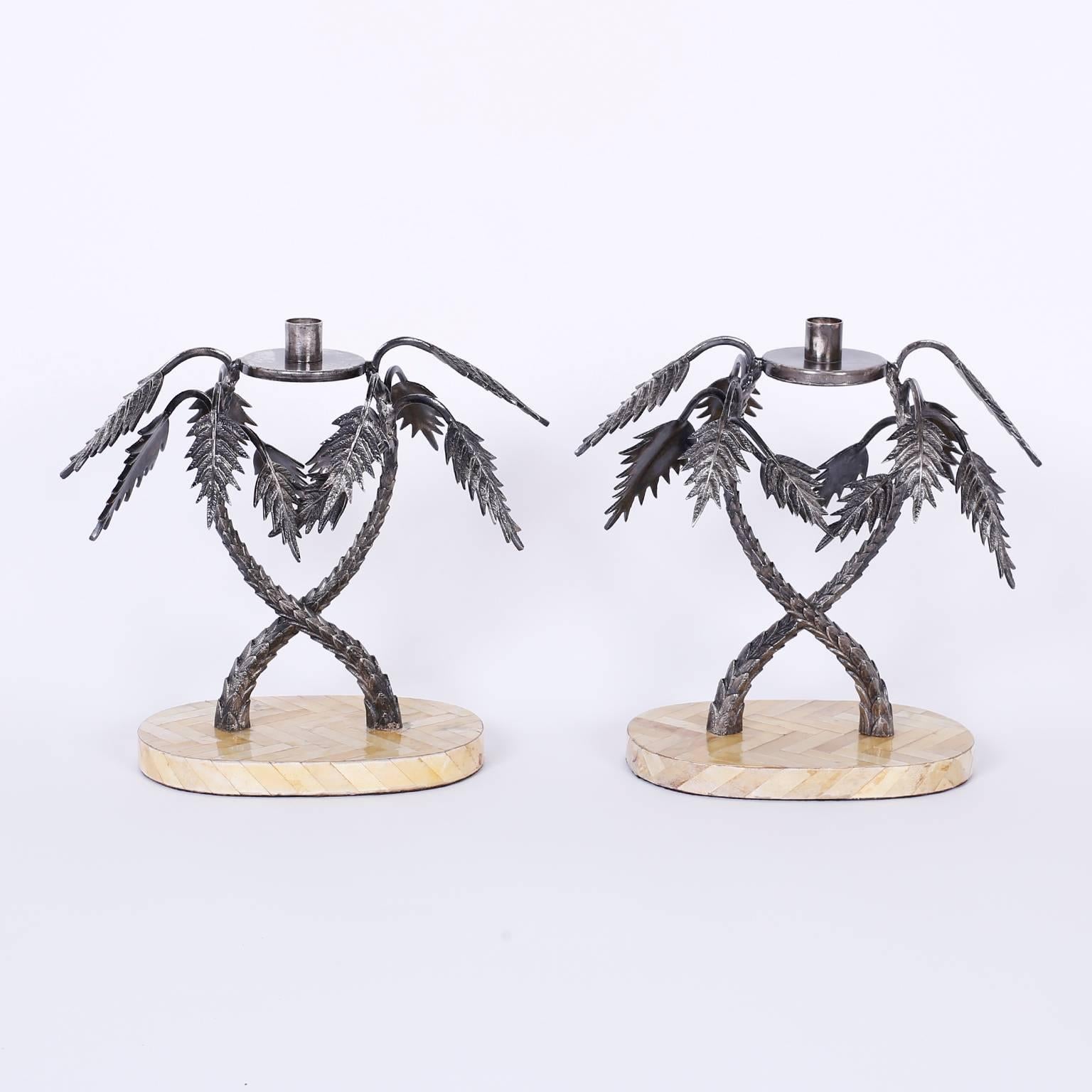Unusual pair of candlesticks composed of two intertwined palm trees crafted with silvered metal on a tessellated lamb skin base.