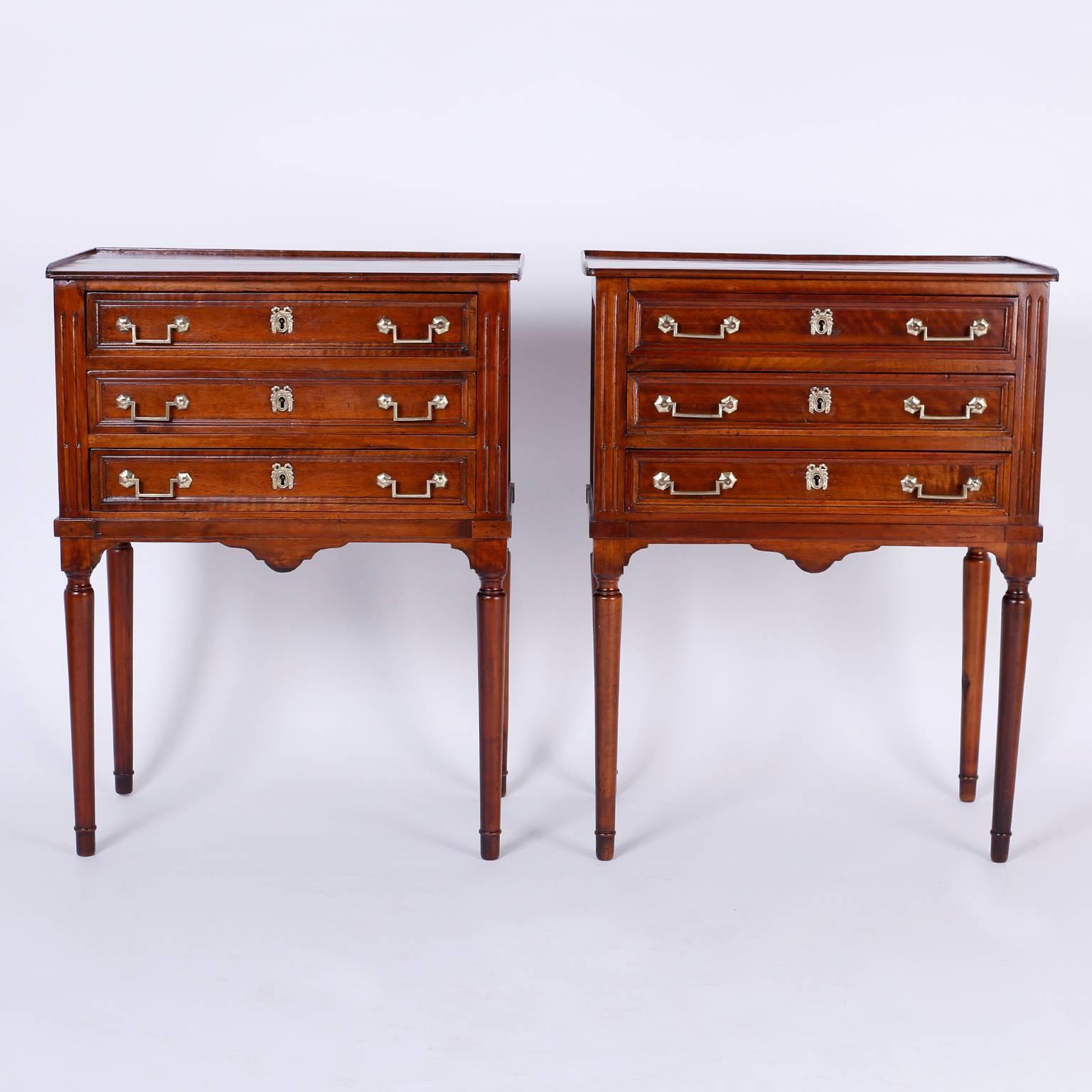 Pair of refined French three-drawer stands expertly crafted by hand with richly grained mahogany in the style of Louis XVI. The tops are single plank with a slight gallery. The sides and drawer faces are paneled. The case sits on elegant turned legs