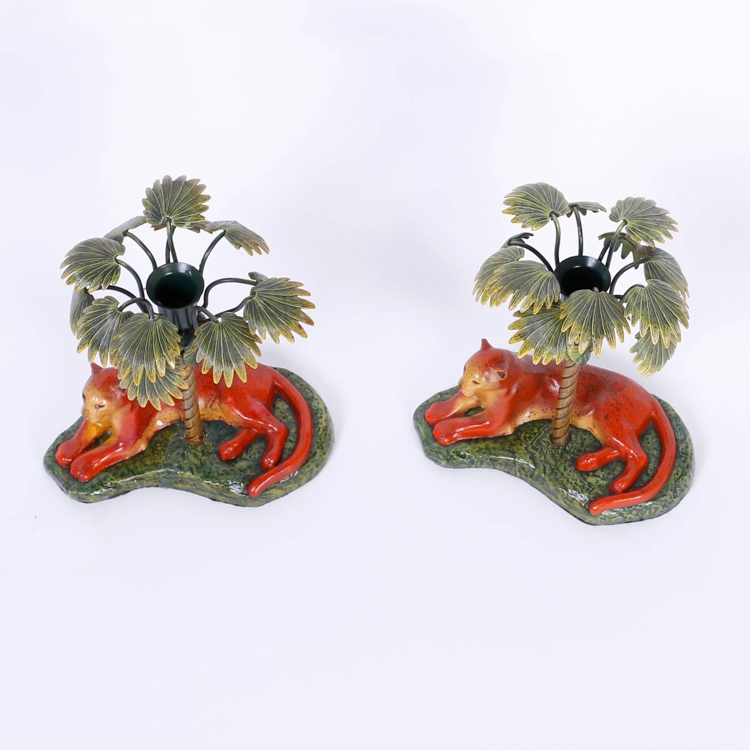 Alluring pair of painted metal candlesticks depicting a big cat in repose relaxing under a palm tree.