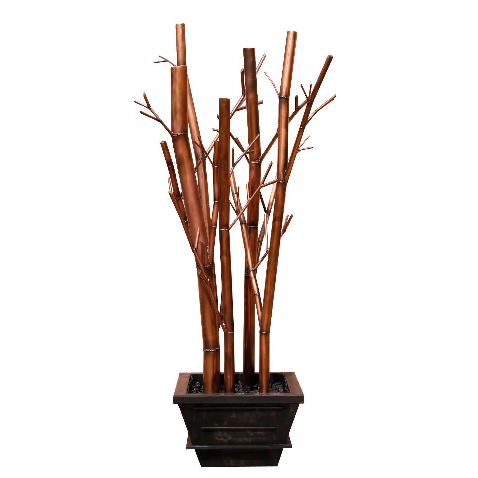 Chic pair of Asian Modern stylized studio sculptures crafted with iron and painted with a lacquered faux copper technique. The bamboo shoots are set in Classic iron planters. The overall elegance is not betrayed by the large-scale.