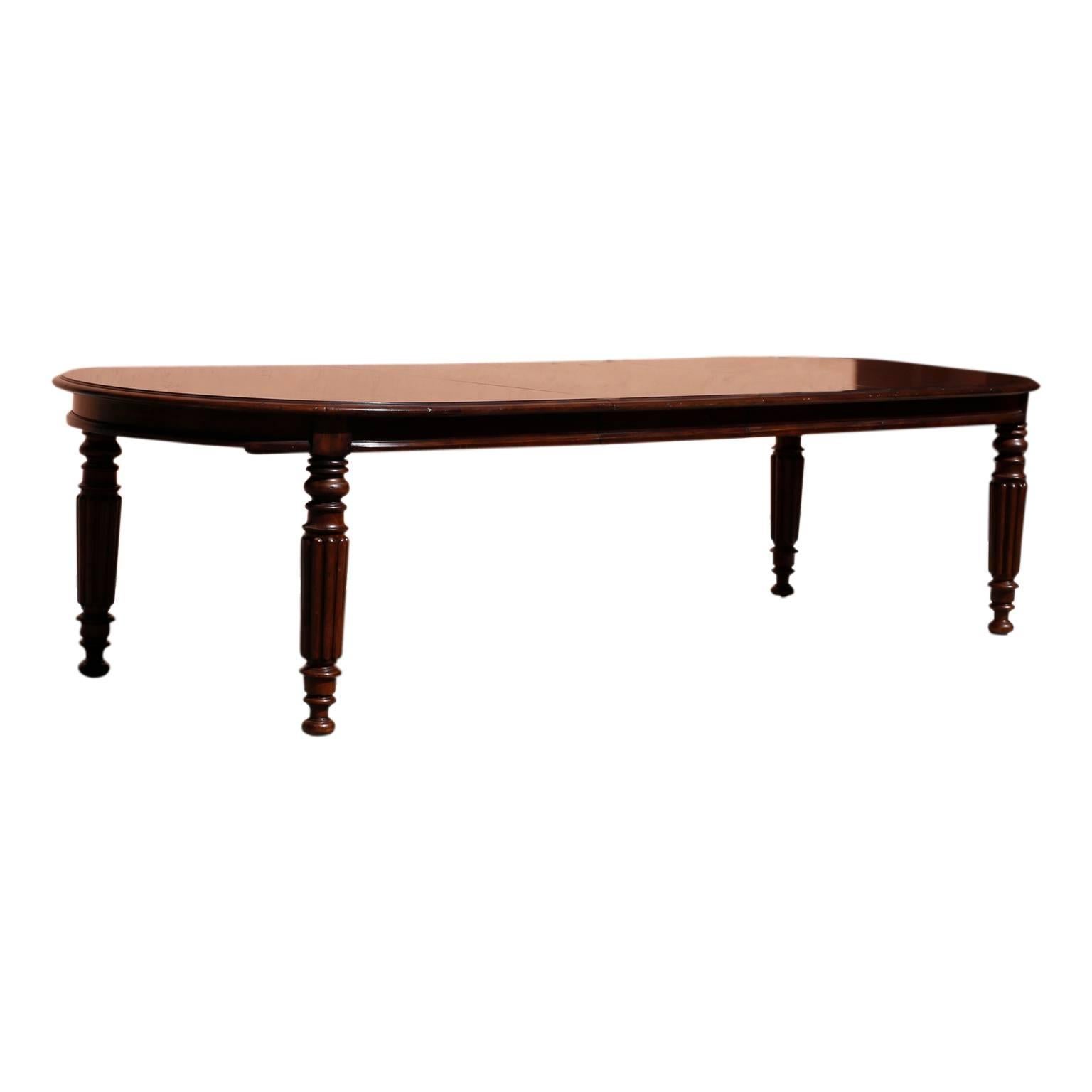 Vintage mahogany dining table with generous proportions that with both leaves will seat 12 comfortably. Having an elongated oval shaped top and four Sheridan style turned and beaded legs. Signed on the under side Lauren. 

Without leaves width is