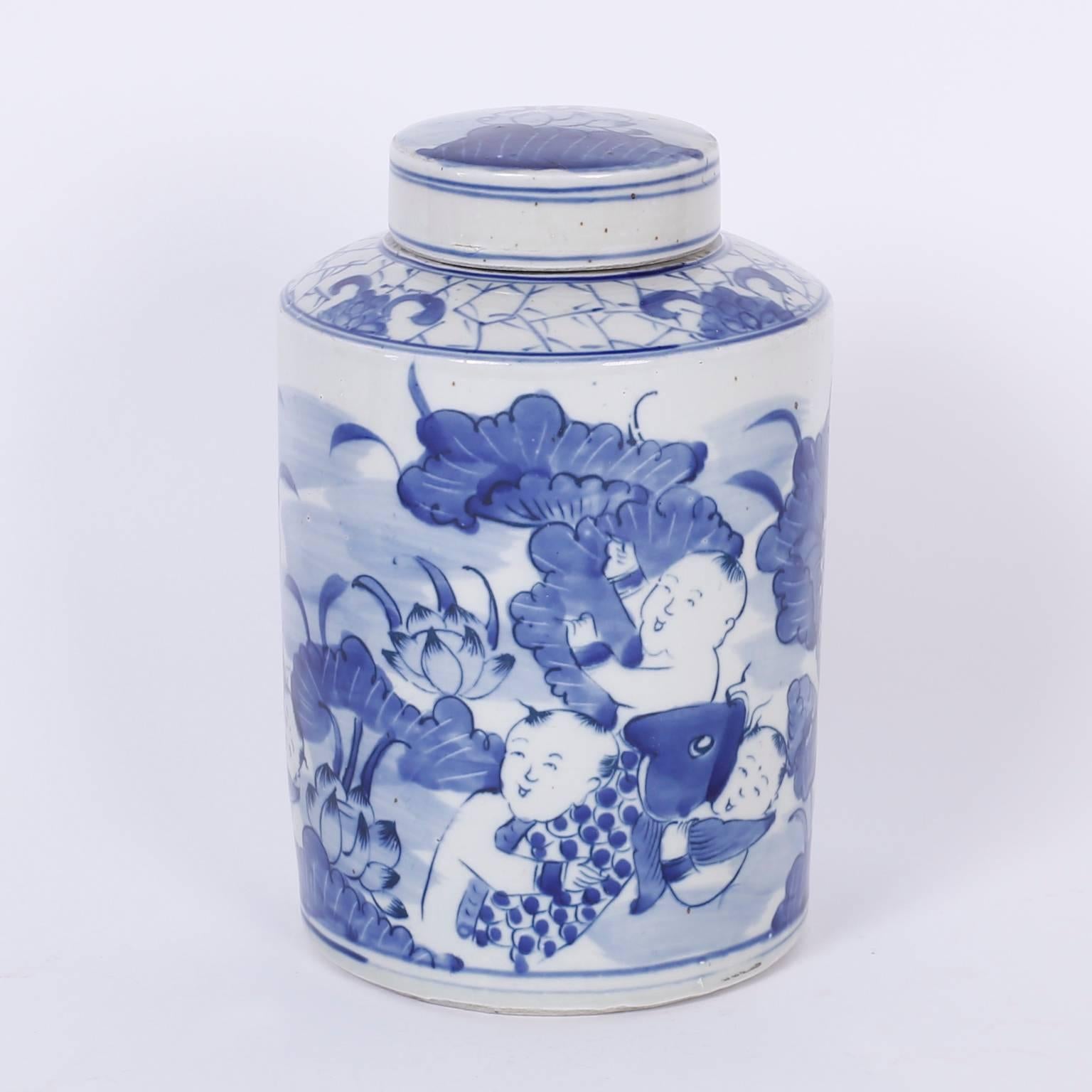 A pair of Chinese porcelain lidded jars decorated in Classic blue and white depicting children with fish and aquatic flora.
 