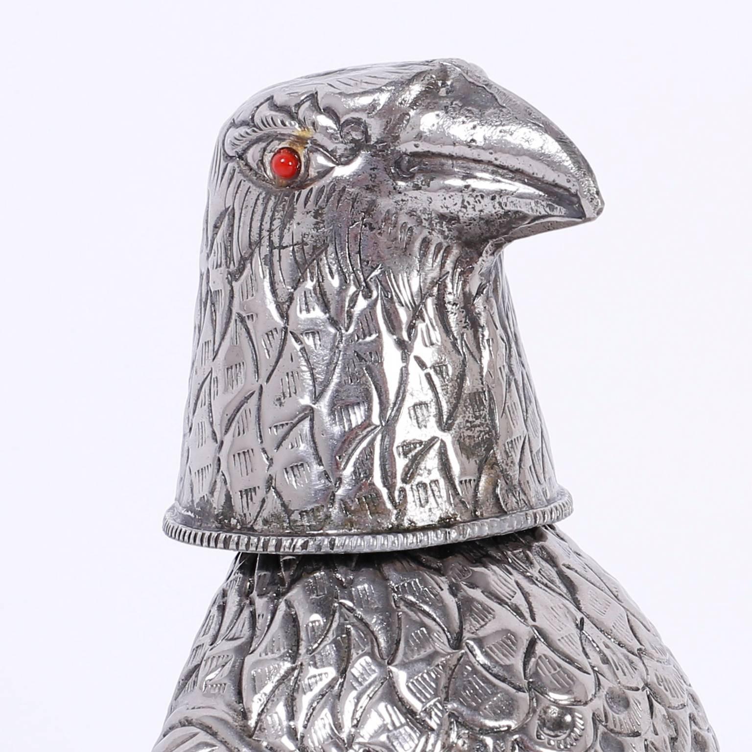 Amusing silvered metal decanter or flask depicting a curious stylized falcon or bird with glass eyes and a removable head.