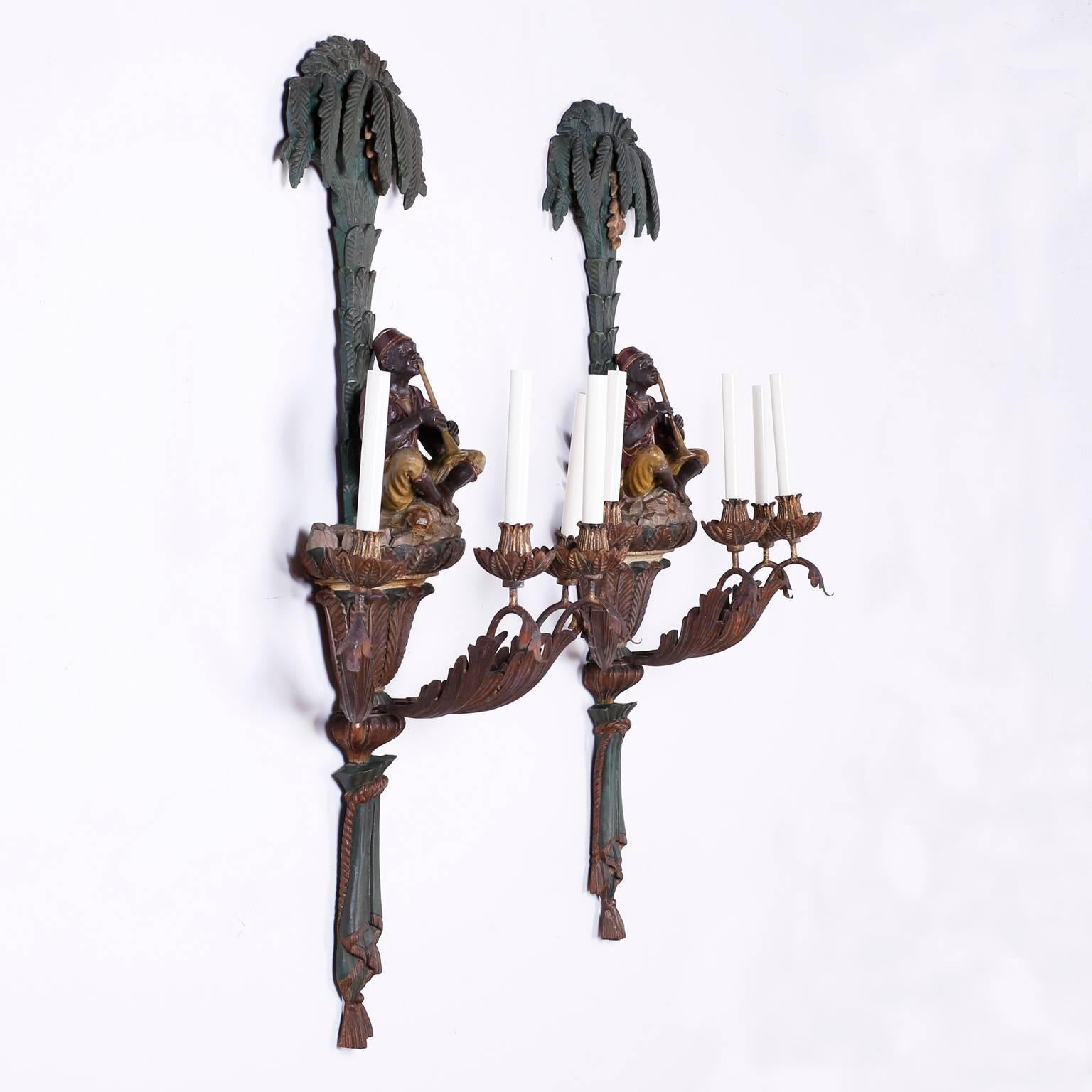Rare and dramatic pair of carved wood French sconces depicting polychrome Moroccan or Moorish musicians under coconut palm trees. Each sconce has four lights on metal arms with acanthus leaves connected to a carved center bulb stylized carved rope,