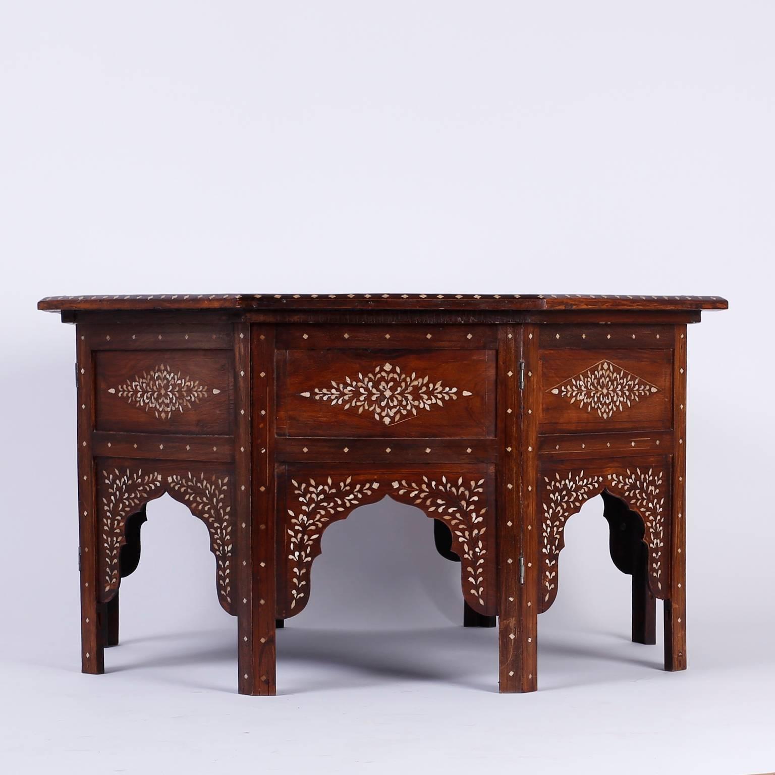 Syrian octagon coffee or cocktail table very well crafted with rosewood and ebony and decorated with bone inlays. The top is a floral rosewood and bone mosaic and the eight panel base has floral inlays and architectural arches. Works well in Anglo