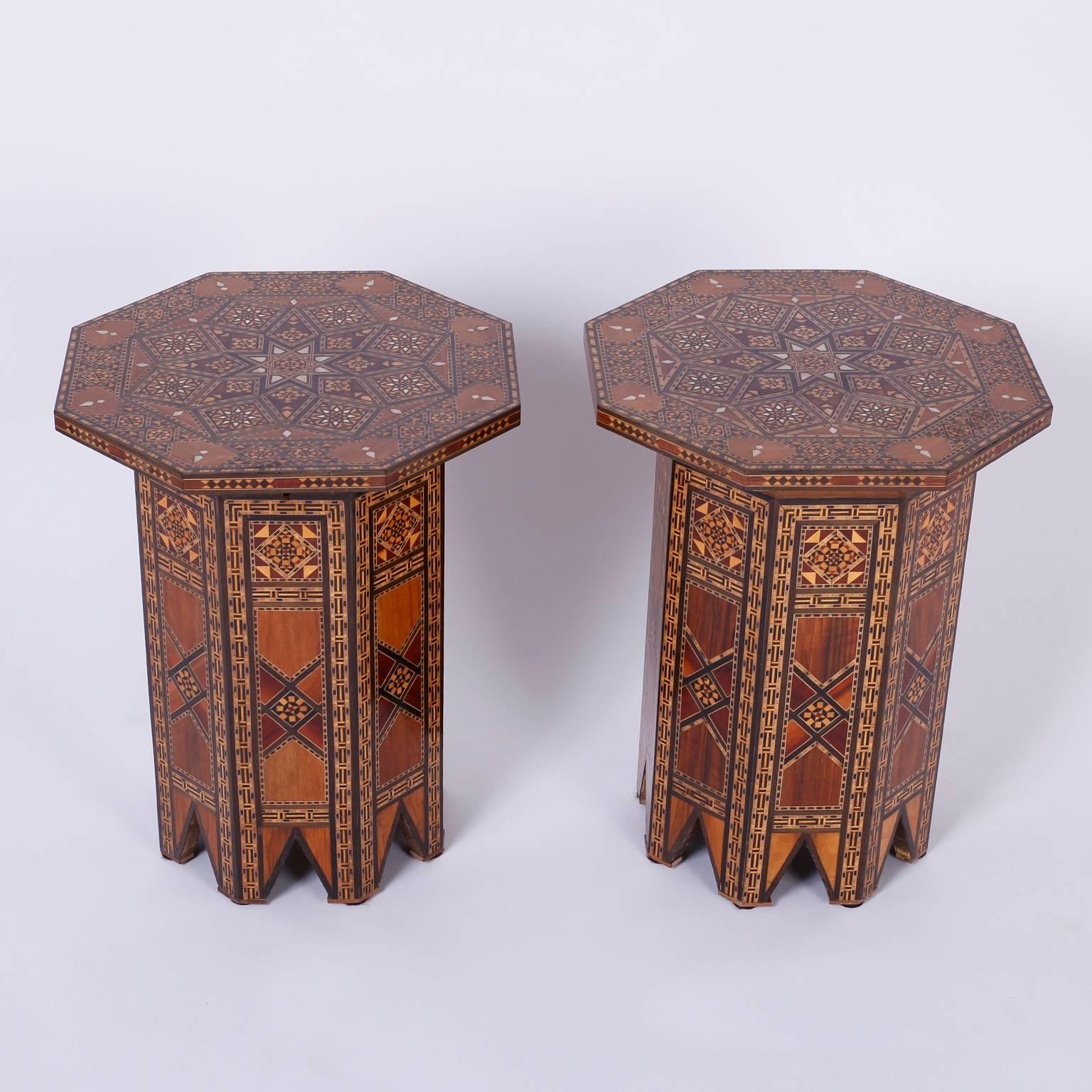 Dynamic pair of Syrian tables expertly crafted with exotic hard woods and displaying remarkable marquetry and inlays including mother-of-pearl, mahogany, and ebony. The tops are hinged lids to storage compartments. The bases are octagonal and
