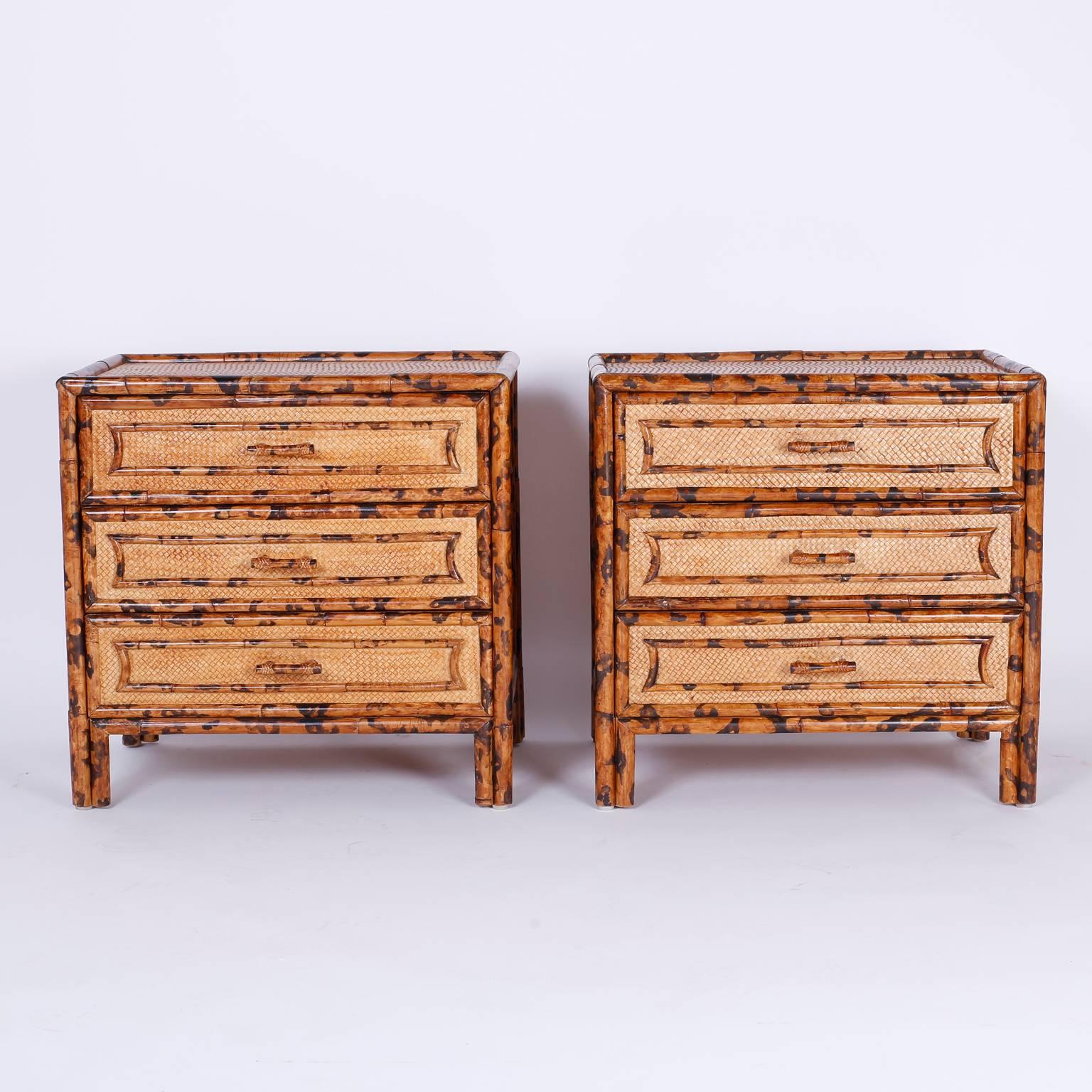 Pair of British Colonial or West Indies style three drawer nightstands, or bedside tables with soothing organic colors and textures. Having a faux burnt bamboo trim and all-over a grass cloth background.