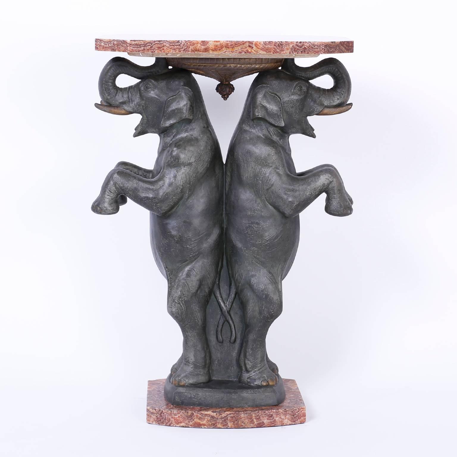 Art Deco pedestal, table or stand cast in a durable metal depicting two back to back elephants. The top and base are a rare red quartz named Rhodochrosite. This piece is signed by the noted French sculpture Pierre Sega.