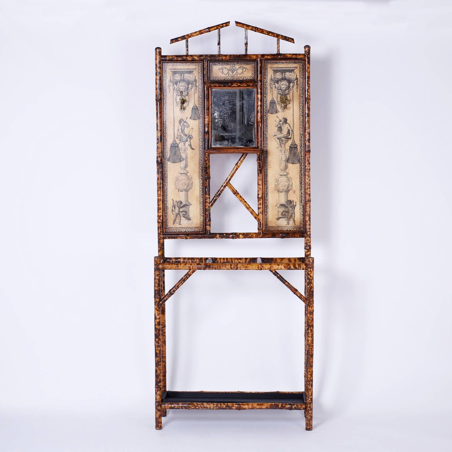 Antique 19th century English burnt bamboo hall tree with built in umbrella or cane stand and featuring brass coat hooks and background panels decorated with classical decoupage.