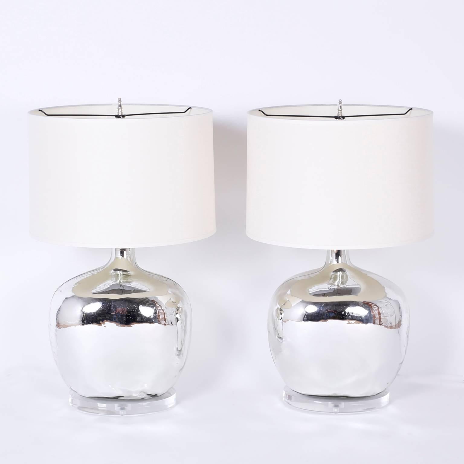 Pair of exclusive silver glass table lamps custom designed by F. S. Henemader. Featuring a chic handblown form crafted with reverse mirrored glass and presented on custom Lucite bases.
    