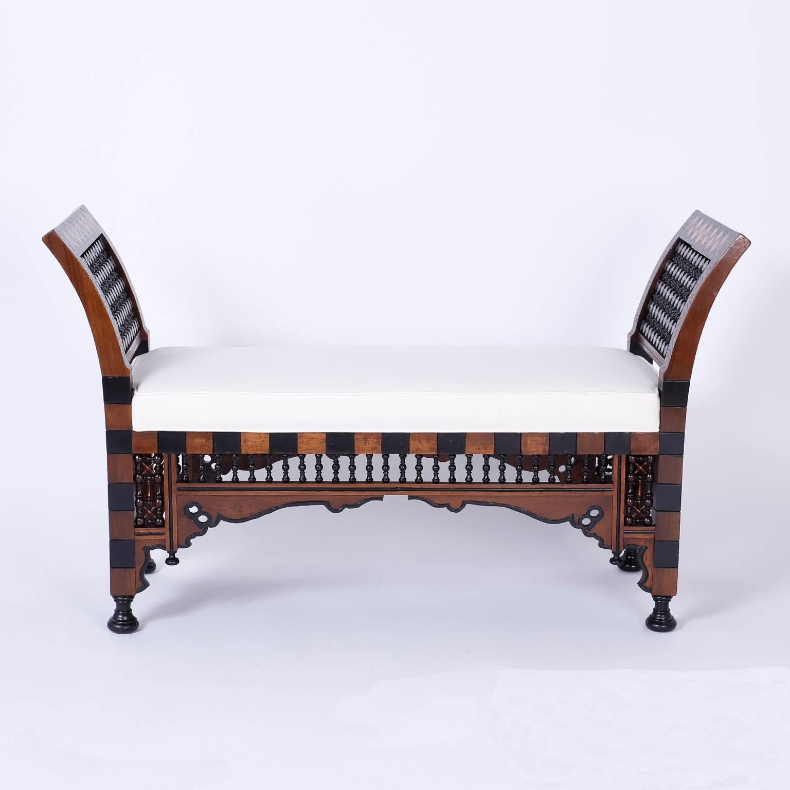 Syrian bench featuring an exotic mixture of walnut, ebonized walnut, stick and ball panels, architectural arches, finials, inlaid with mother-of-pearl and turned feet. Perfect proportions. Quality construction and an alluring ambiance make this