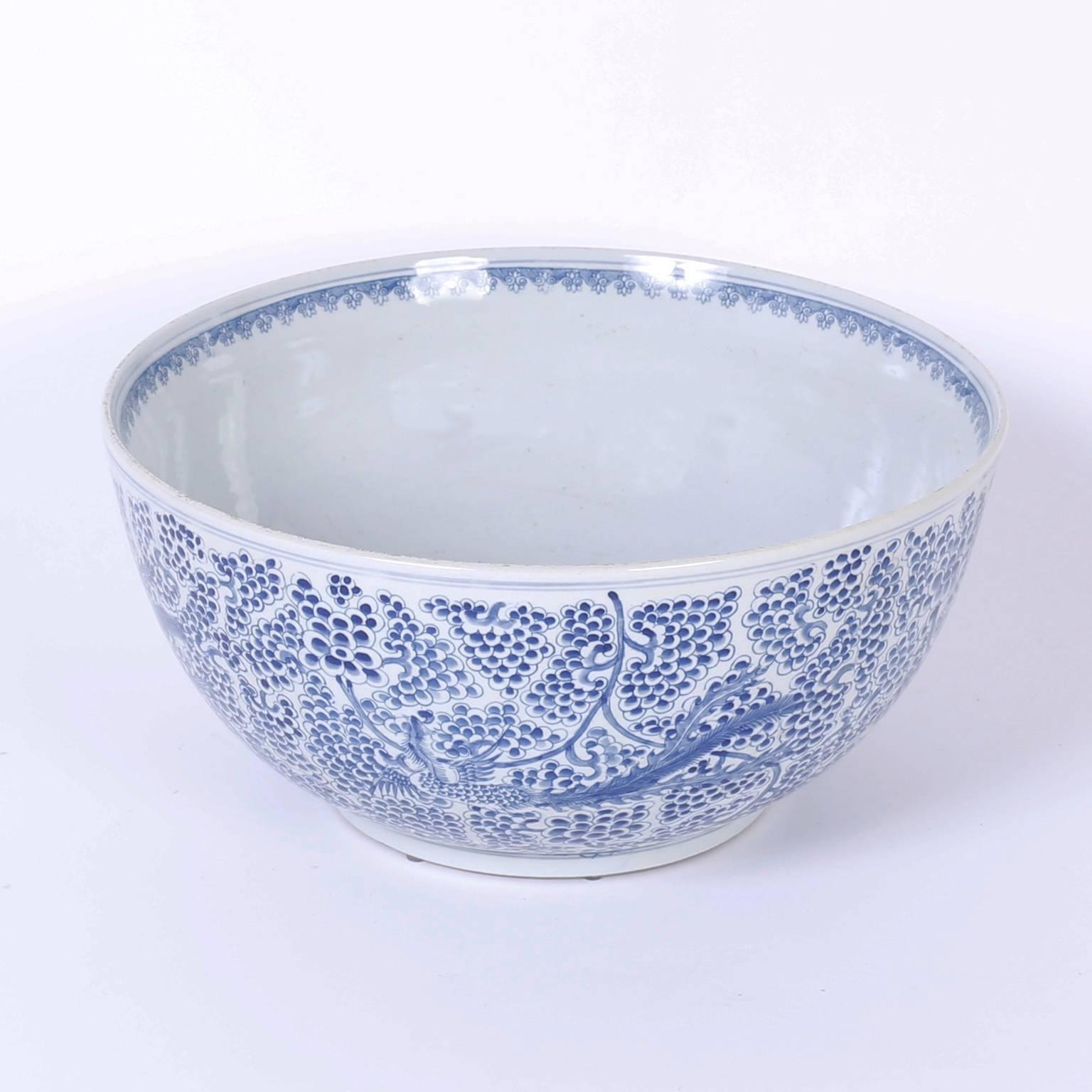 Blue and white Chinese porcelain footed bowl with perfect proportions and hand decorated with phoenix birds against an intricate floral field.
 