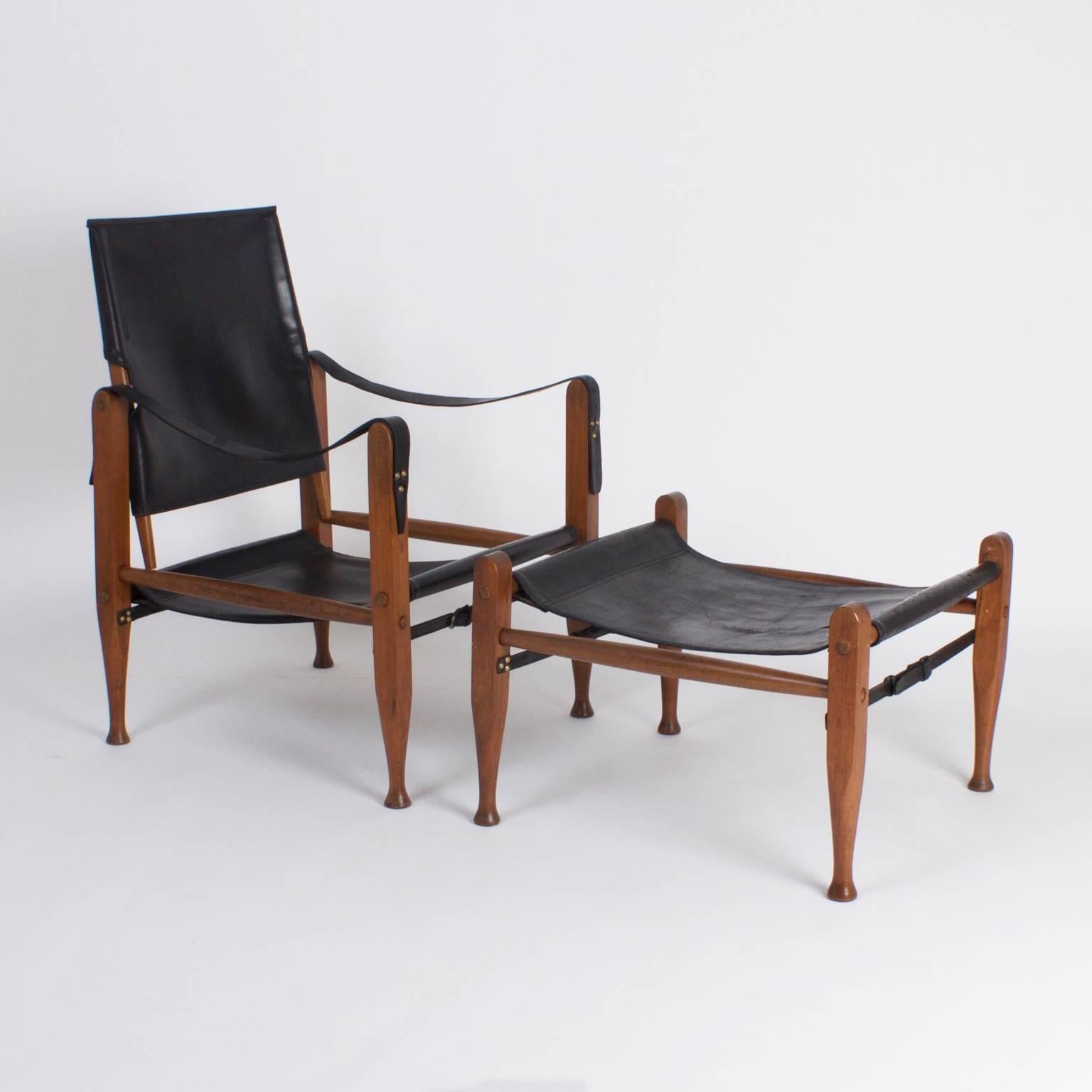 Dapper, Mid-Century safari chair and ottoman crafted with mahogany and soft black leather. Featuring swivel back, sling style seat and arms with elegant lines.

Measures: Chair: H 32, W 22, D 22, SH 13.

Ottoman: H 16, W 22, D 22.