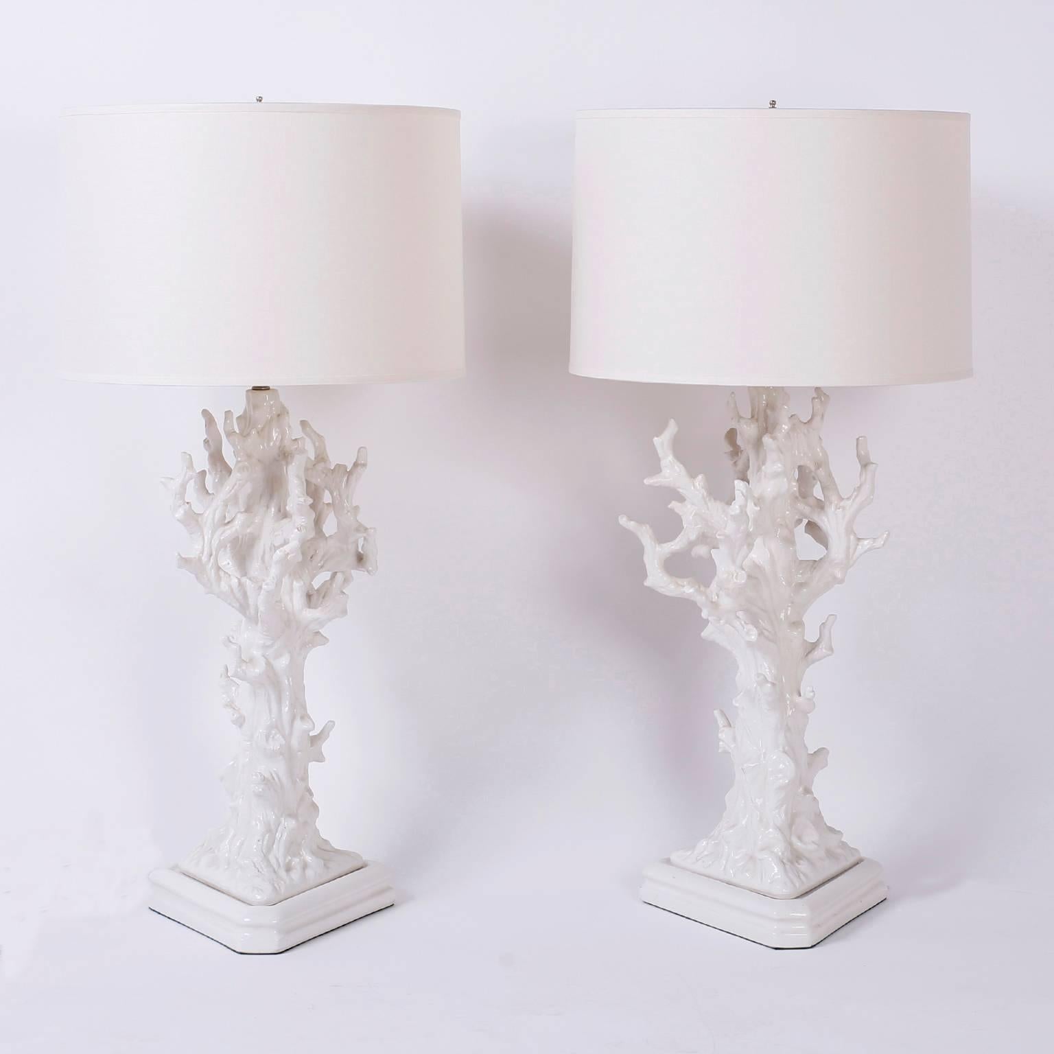 Striking pair of midcentury white porcelain table lamps depicting coral structures and set on triangular porcelain bases. Perfect for coastal or island living or any living that needs a decorative pop. Newy li.

 