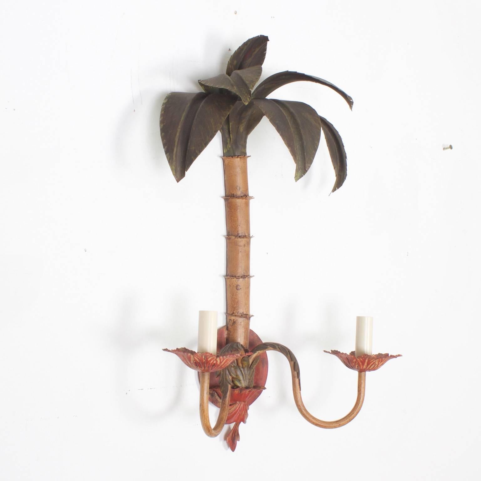 Pair of Mid-Century tole, two-light stylized palm tree sconces, with a rustic Mediterranean palette and a whimsical tropical vibe. Newly wired. 
Check out our other listing for a larger pair and a pair of chandeliers.

. 