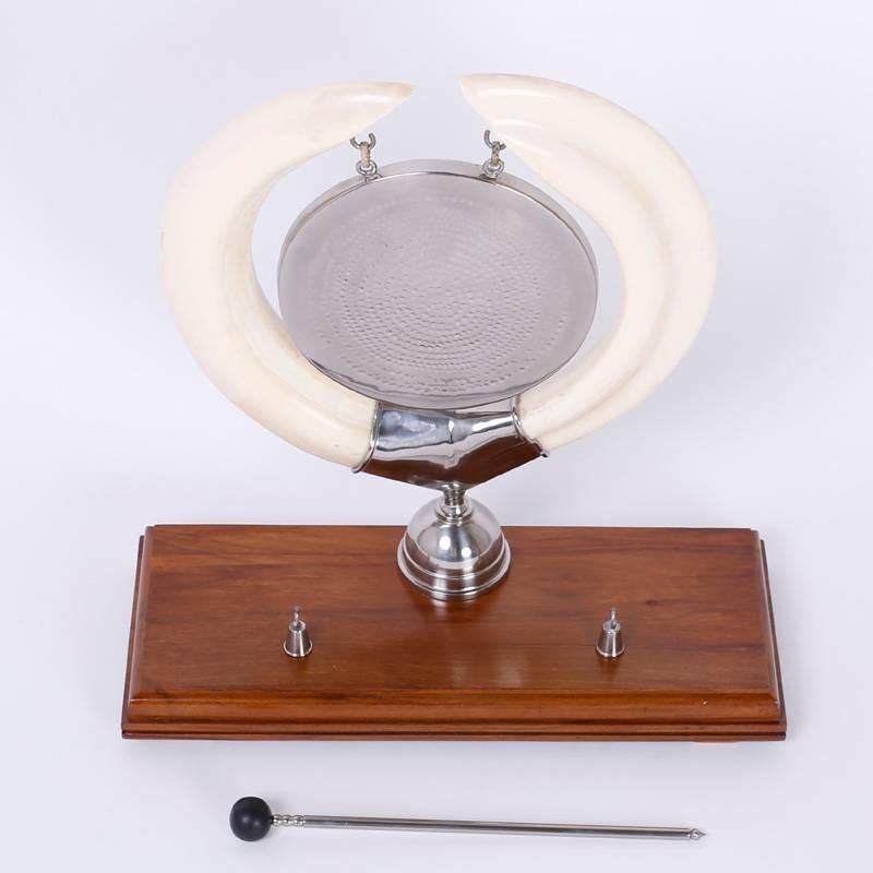 Ce gong de cérémonie élégant, à l'ambiance Art déco, est fabriqué à partir de défenses de morse et de métal argenté et est présenté sur un support classique en acajou. Le gong lui-même est martelé à la main pour une résonance maximale.