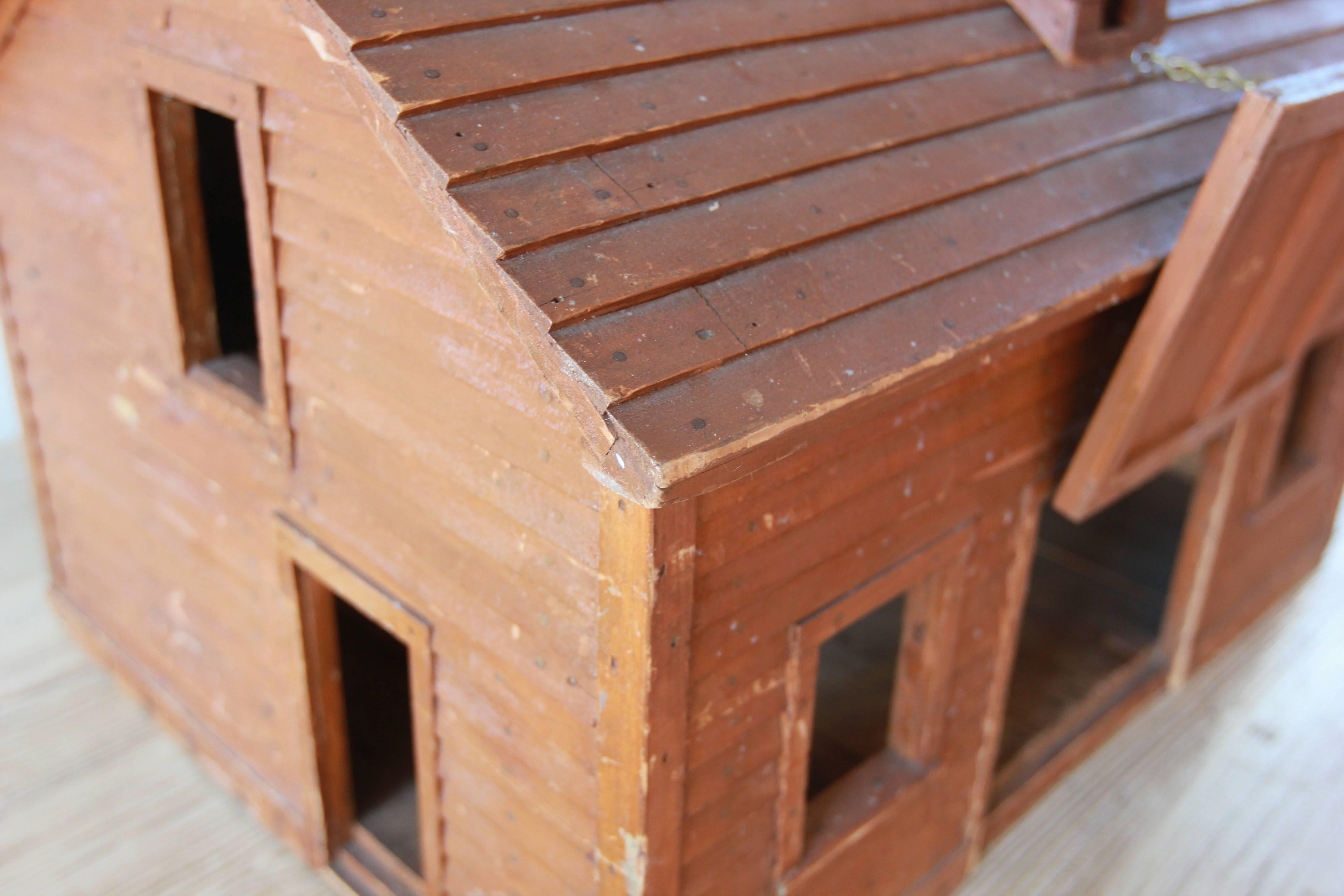 Miniature wood dollhouse with a separate ramp and door on a pivot.