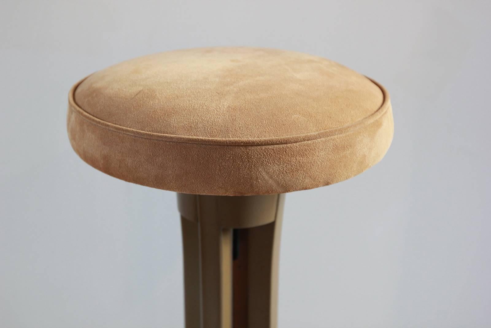 Brown painted stools with curved feet topped with a suede cushion.
