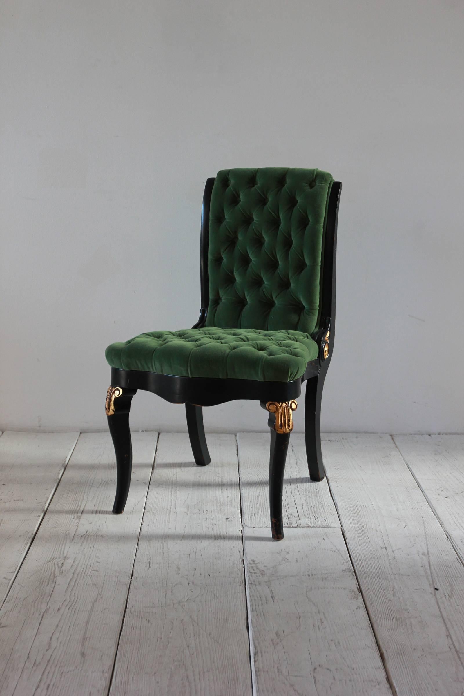 Black and gold painted Regency chair upholstered in green velvet with tufting details.