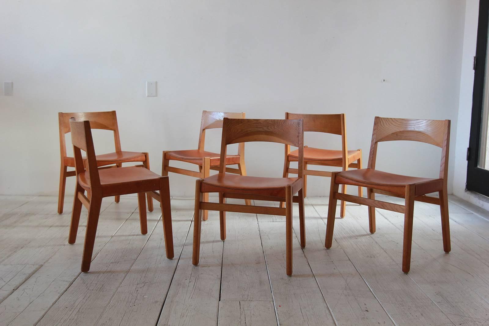 Set of six oak and leather armless dining chairs.