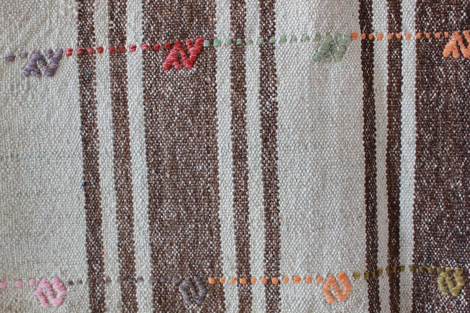 Turkish brown and natural striped rug with pink and orange details.