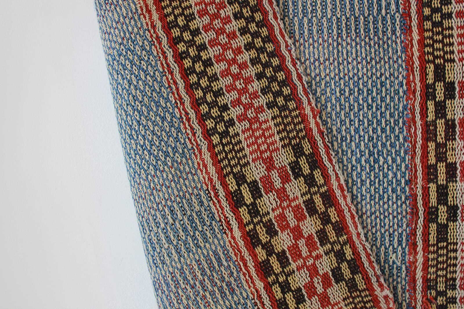Multicolored Chinese woven rug with blue and red stripes.