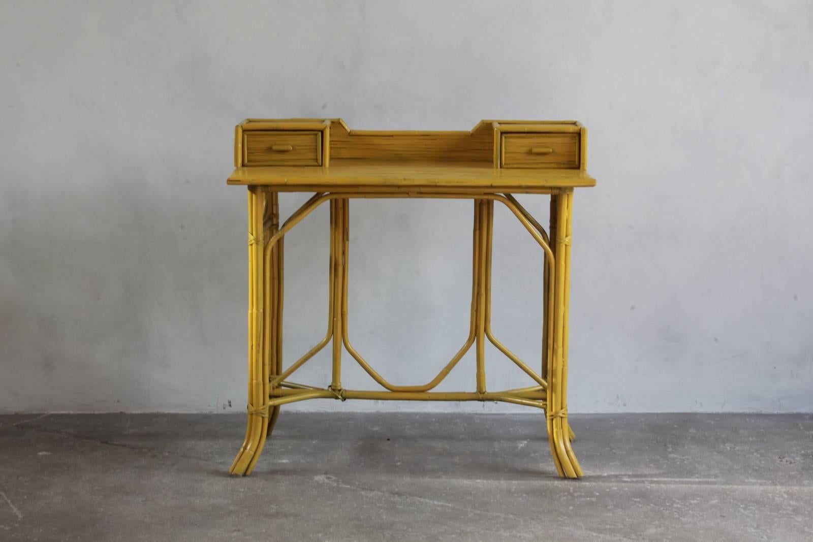 Yellow painted bamboo writing desk with two drawers.