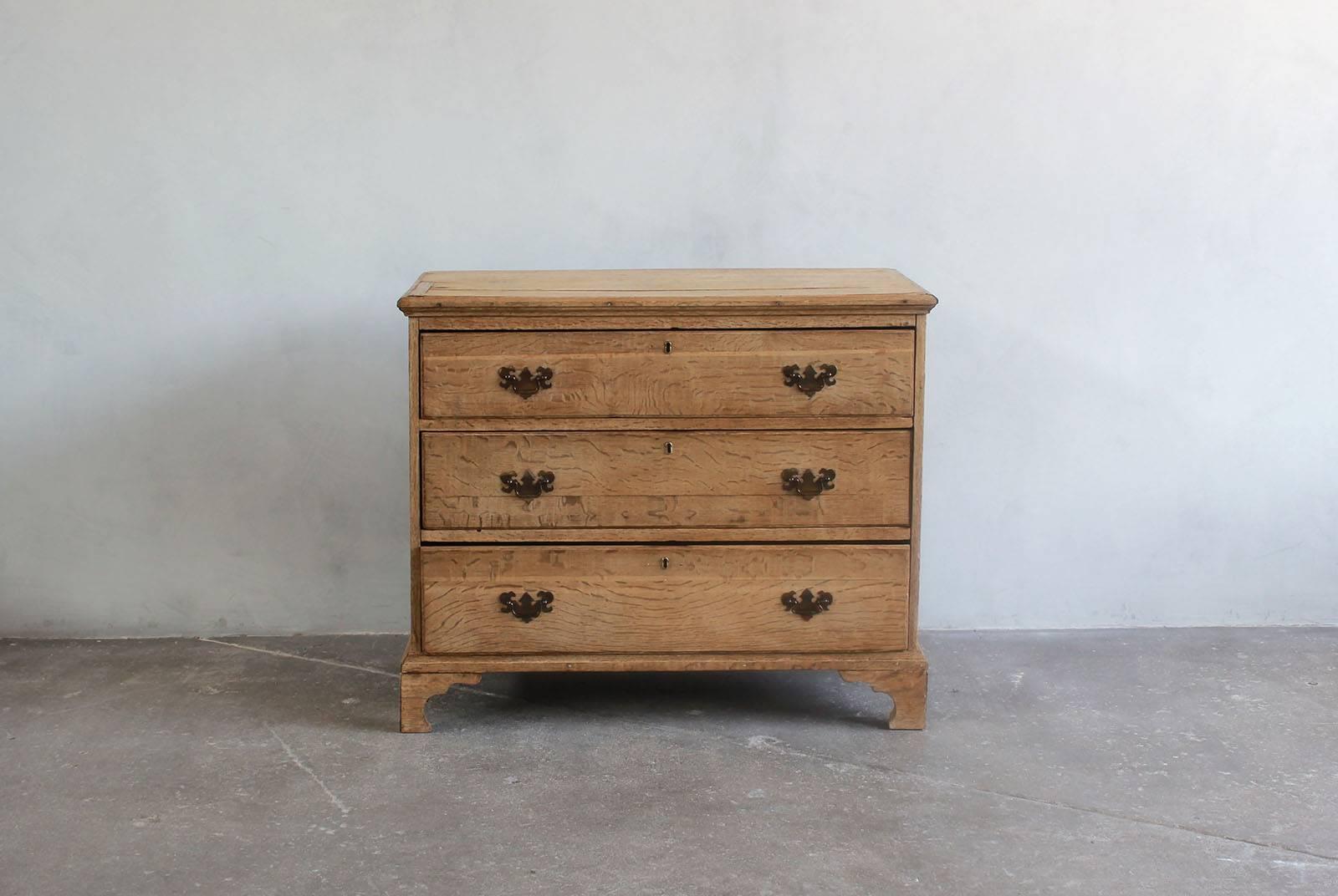 Queen Ann style burled wood three-drawer dresser with brass pulls.