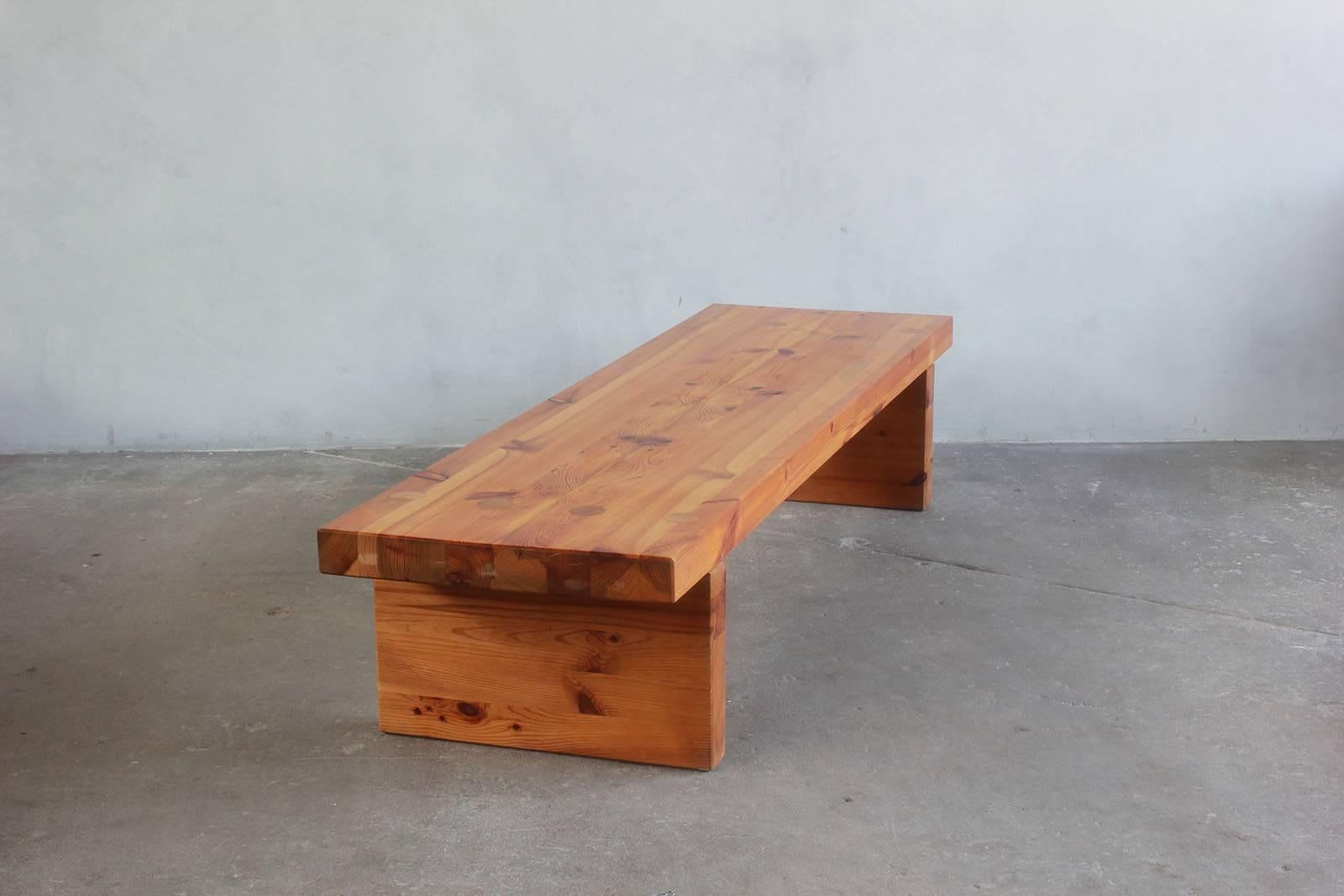 Low and long pine table or bench with simple constructed details.