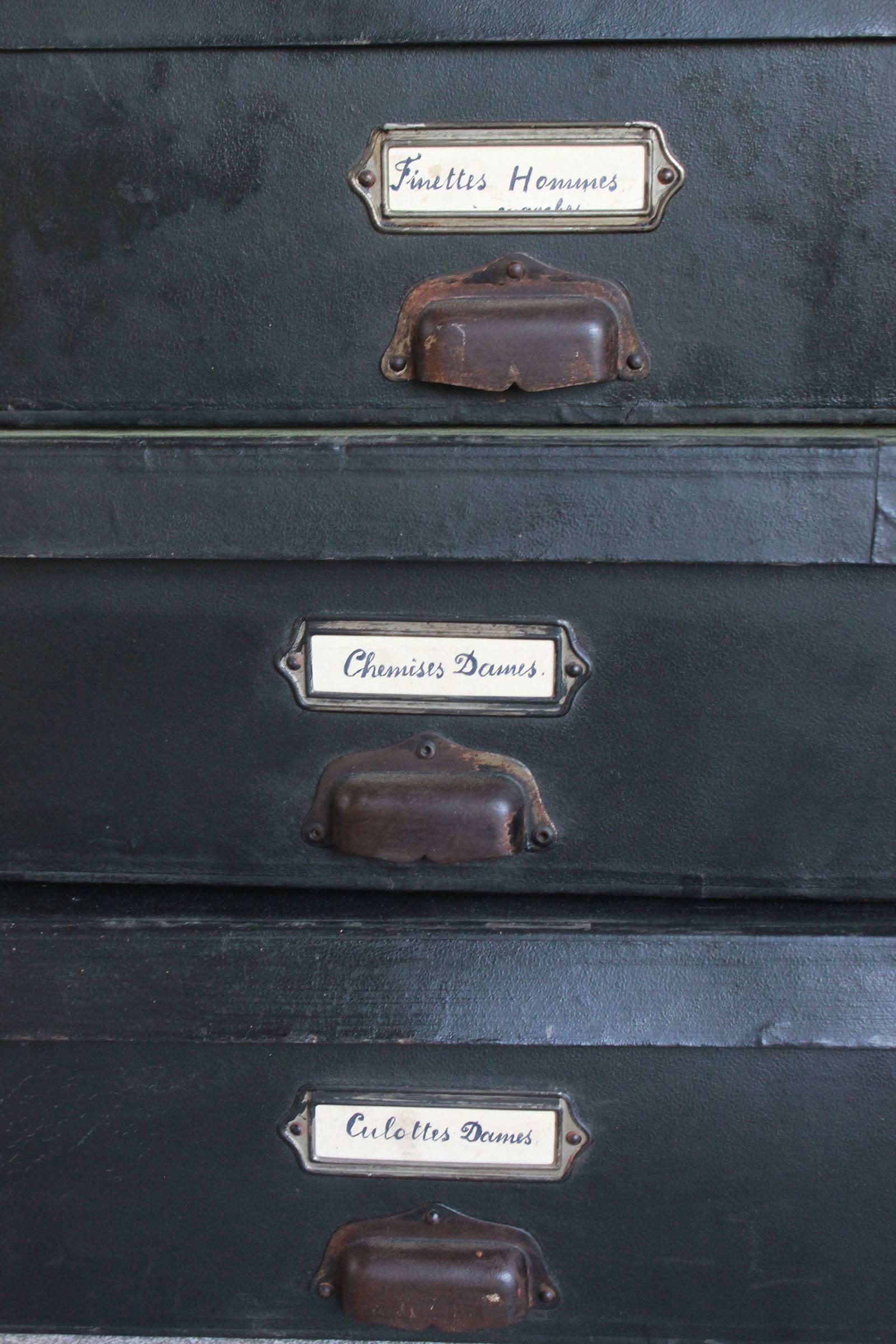 Black boudoir boxes with hand written descriptions with brass pulls.