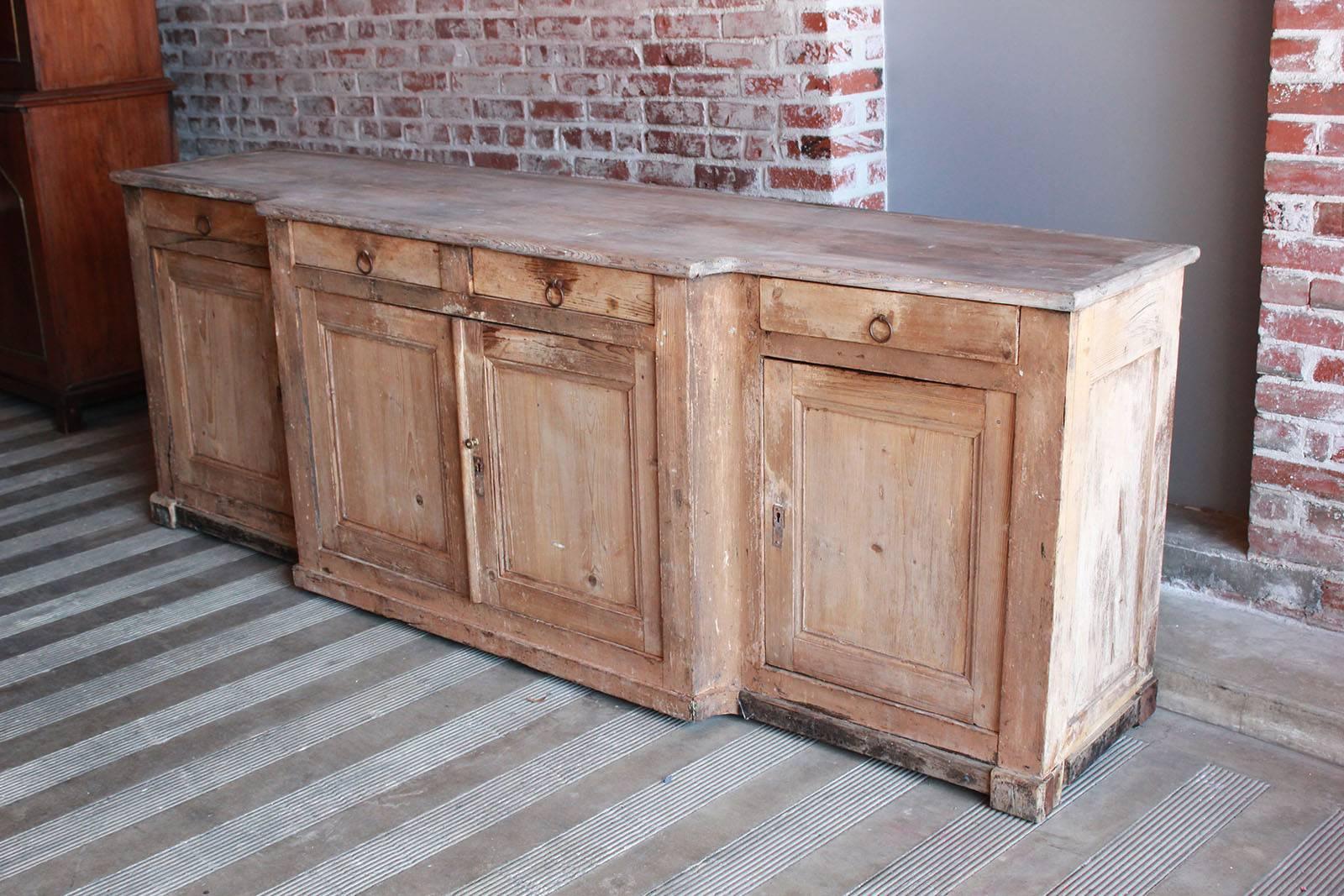 Large beautifully distressed pine sideboard with four doors and four drawers.