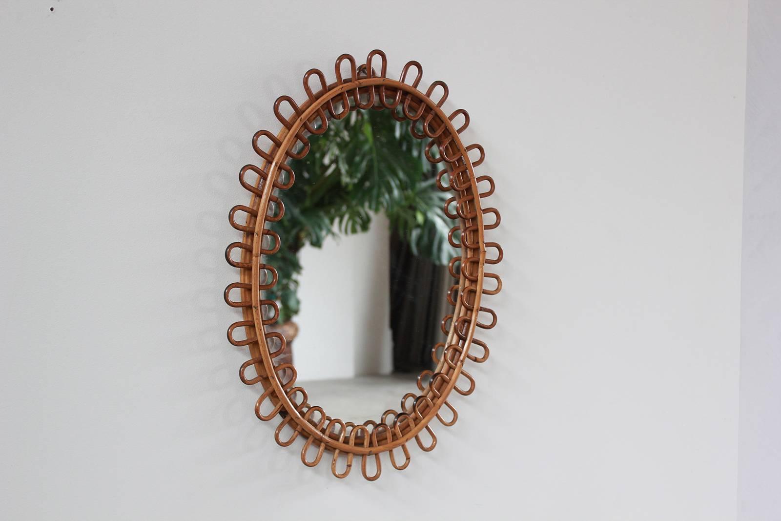 Small curled wicker French oval mirror.