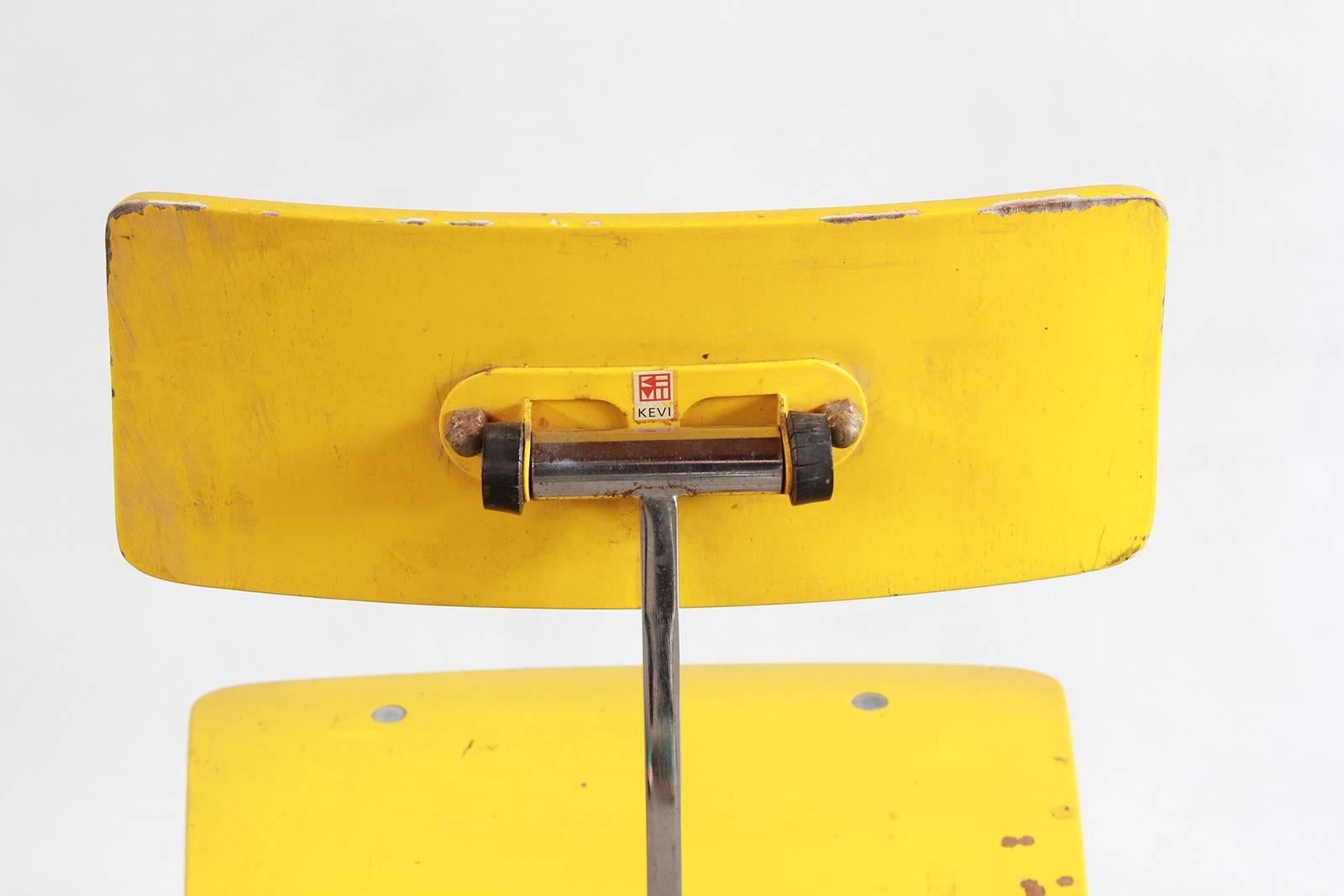 Painted yellow Kevi style desk chair with single pedestal and wheels.