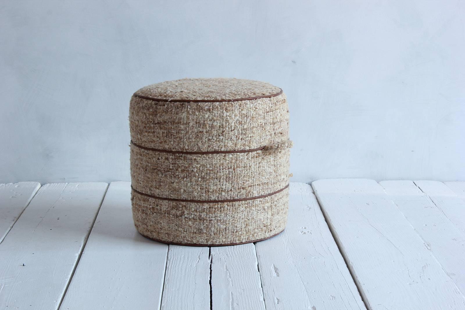 Nickey Kehoe collection small round hassock upholstered in bouclé fabric with leather piping.