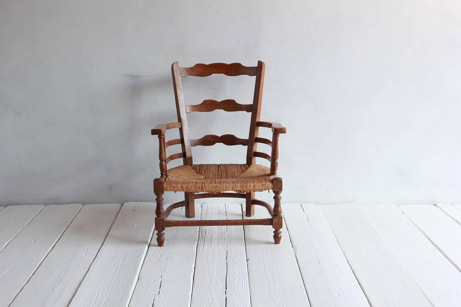 Pair of French low open framed chairs with woven rush seat.