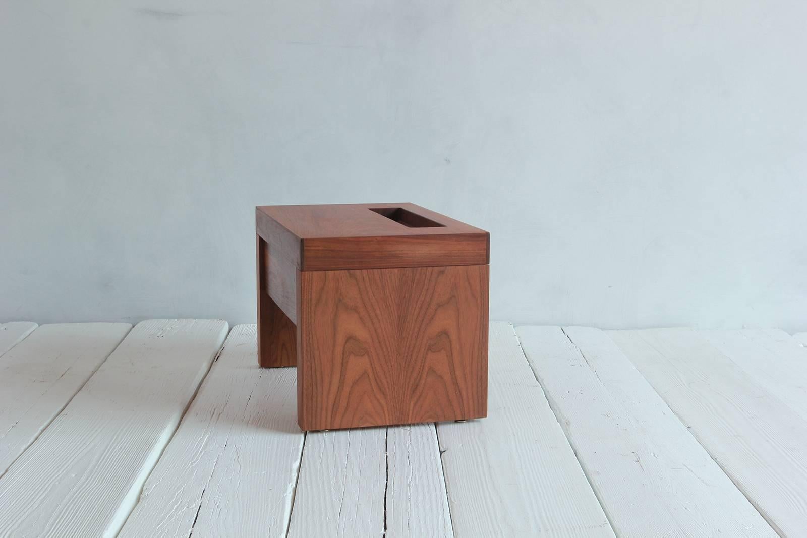 Walnut side table with cut-out niche and hidden single drawer.