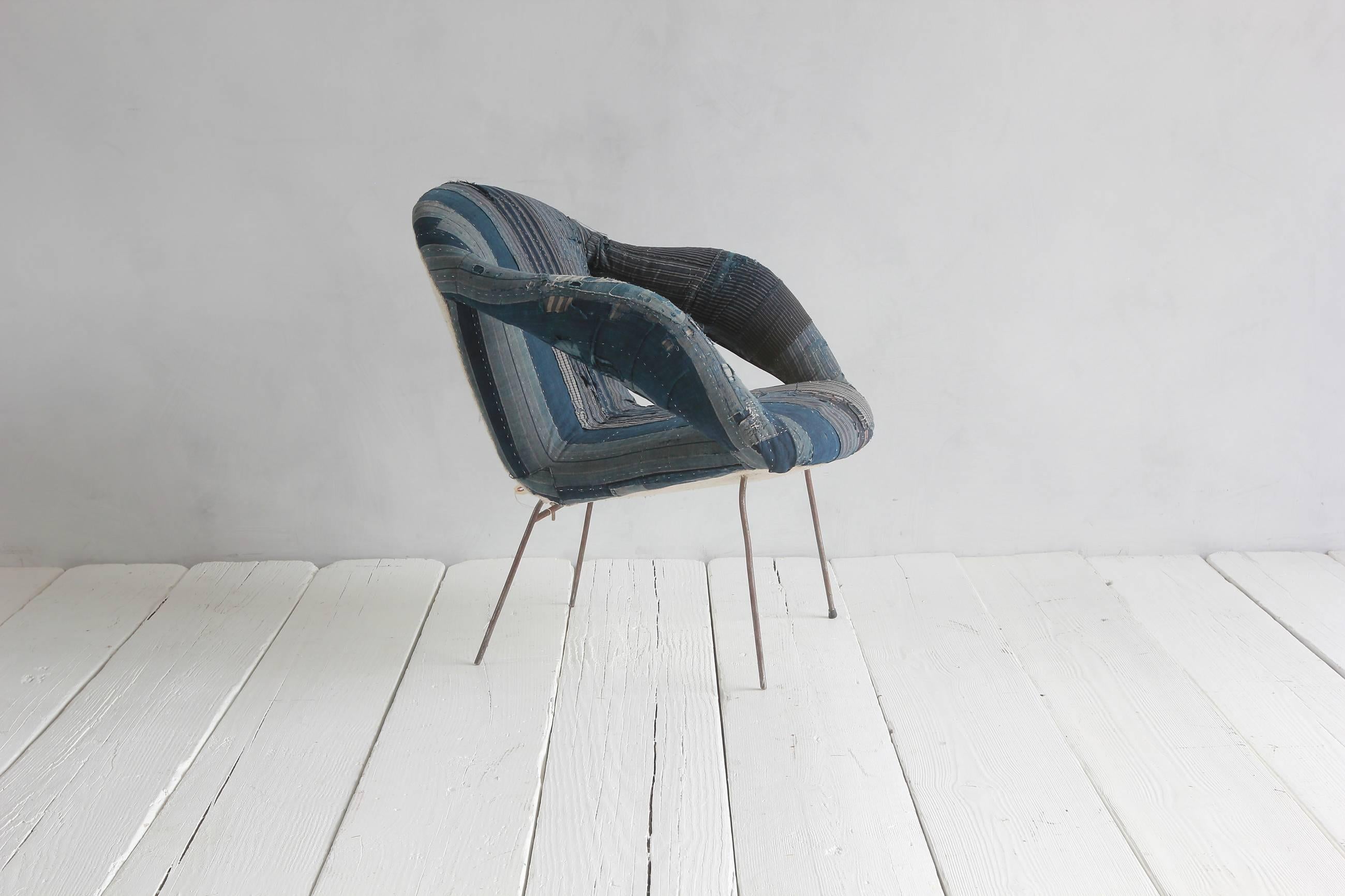 Mid-Century style armchair upholstered in Indigo African fabric with simple metal legs.