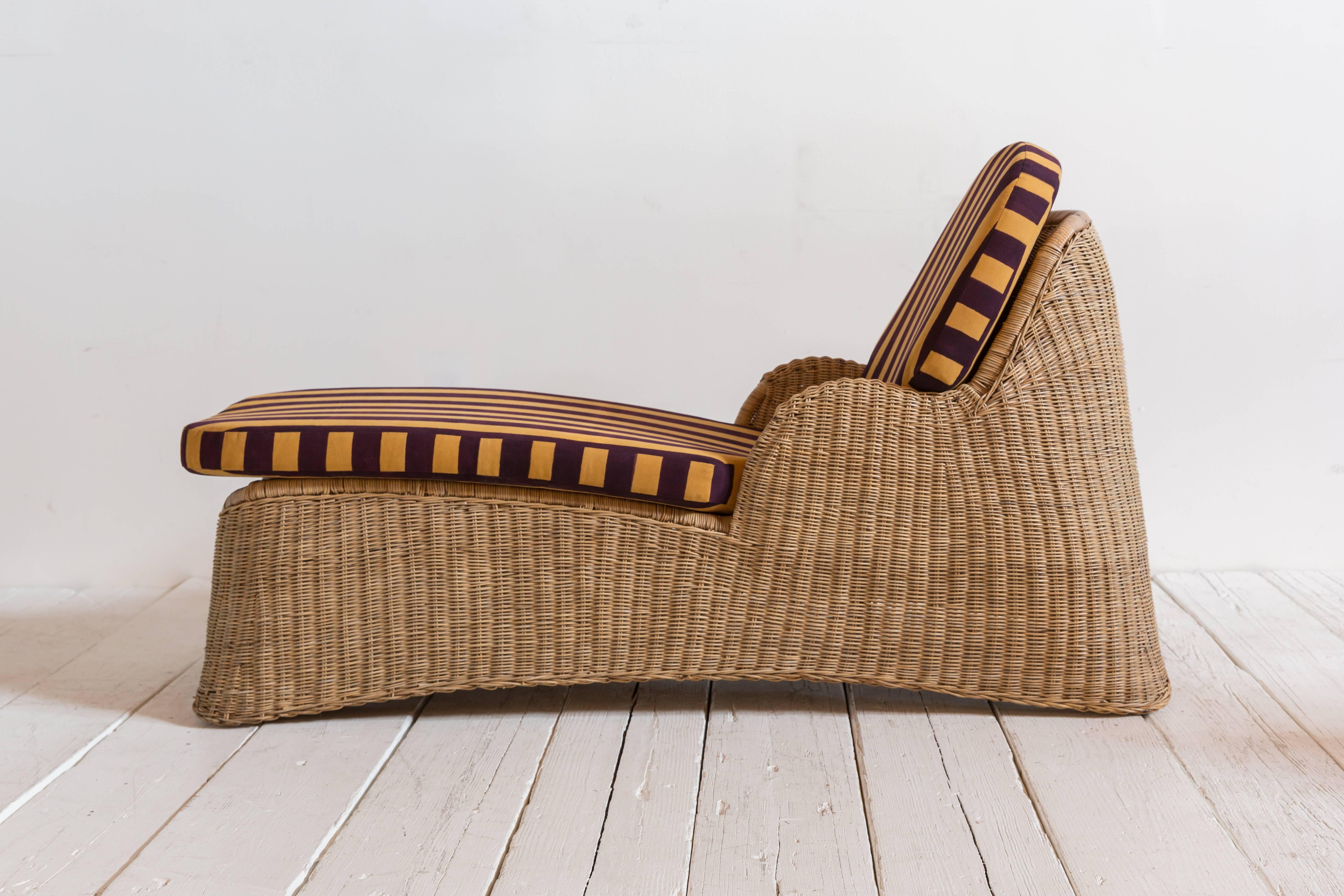 Wicker chaise newly upholstered in Lisa Corti purple and yellow striped fabric.