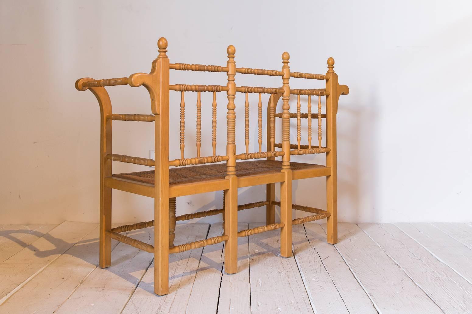 Edwardian Style Light Oak Spindle Bench with Rush Seat and Curved Arms In Distressed Condition In Los Angeles, CA