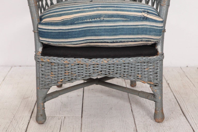 Unique vintage deck chair in faded blue wicker with newly upholstered cushion in vintage African striped mudcloth.