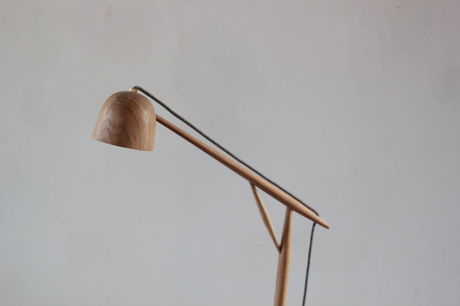 The white oak Crane Floor lamp displays delicate components that celebrate the best qualities of wood craftsmanship. The grain texture stems from the careful and deliberate process of turned wood fabrication. The lamp has a seamless angular design,