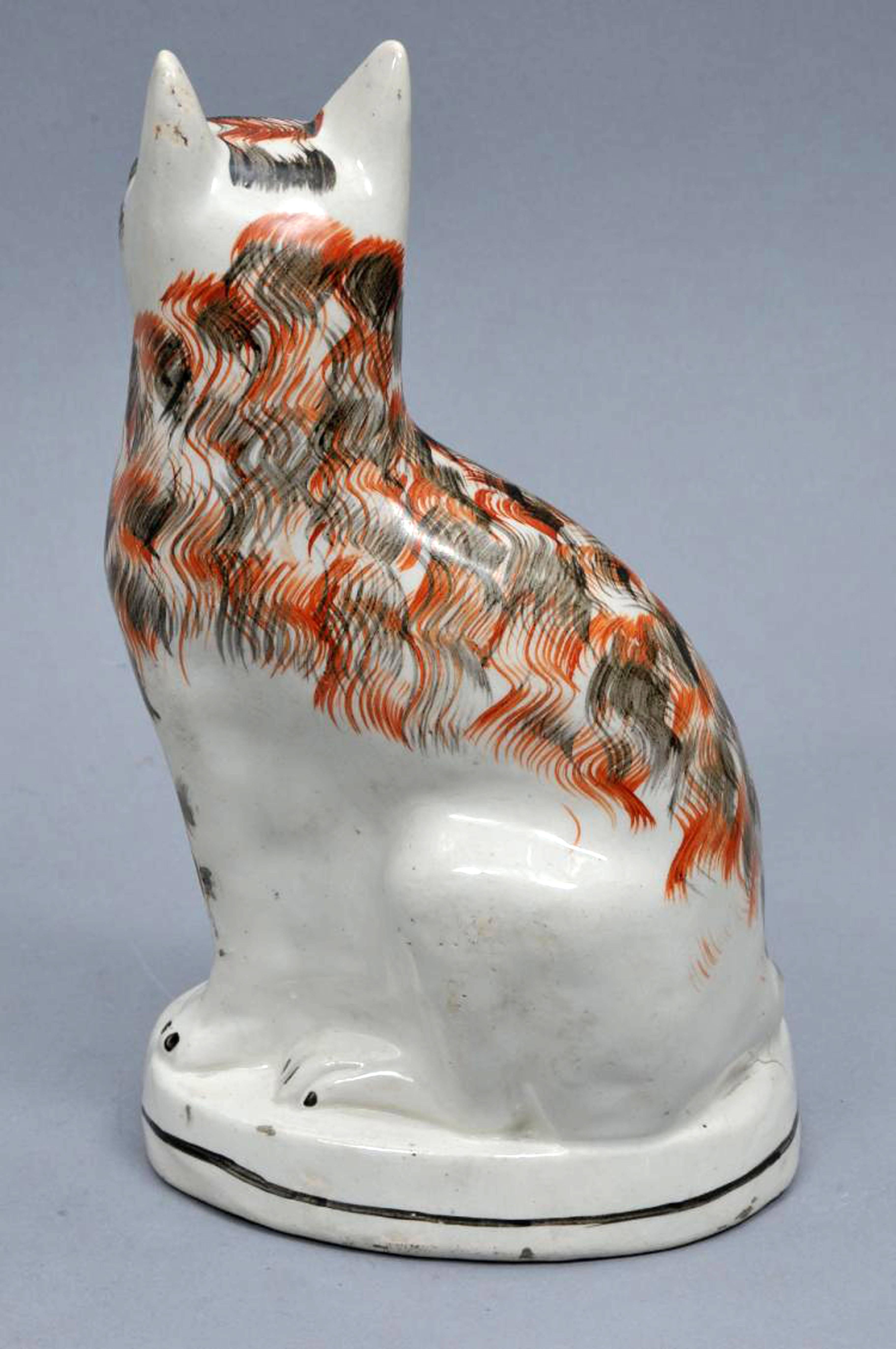 Staffordshire pottery cat, 
circa 1850.

The wonderful cat sits on an oval base on its hindquarters, its ears pricked and is painted whimsically with brown and red fur.

Dimensions: 10 1/2 inches high.
