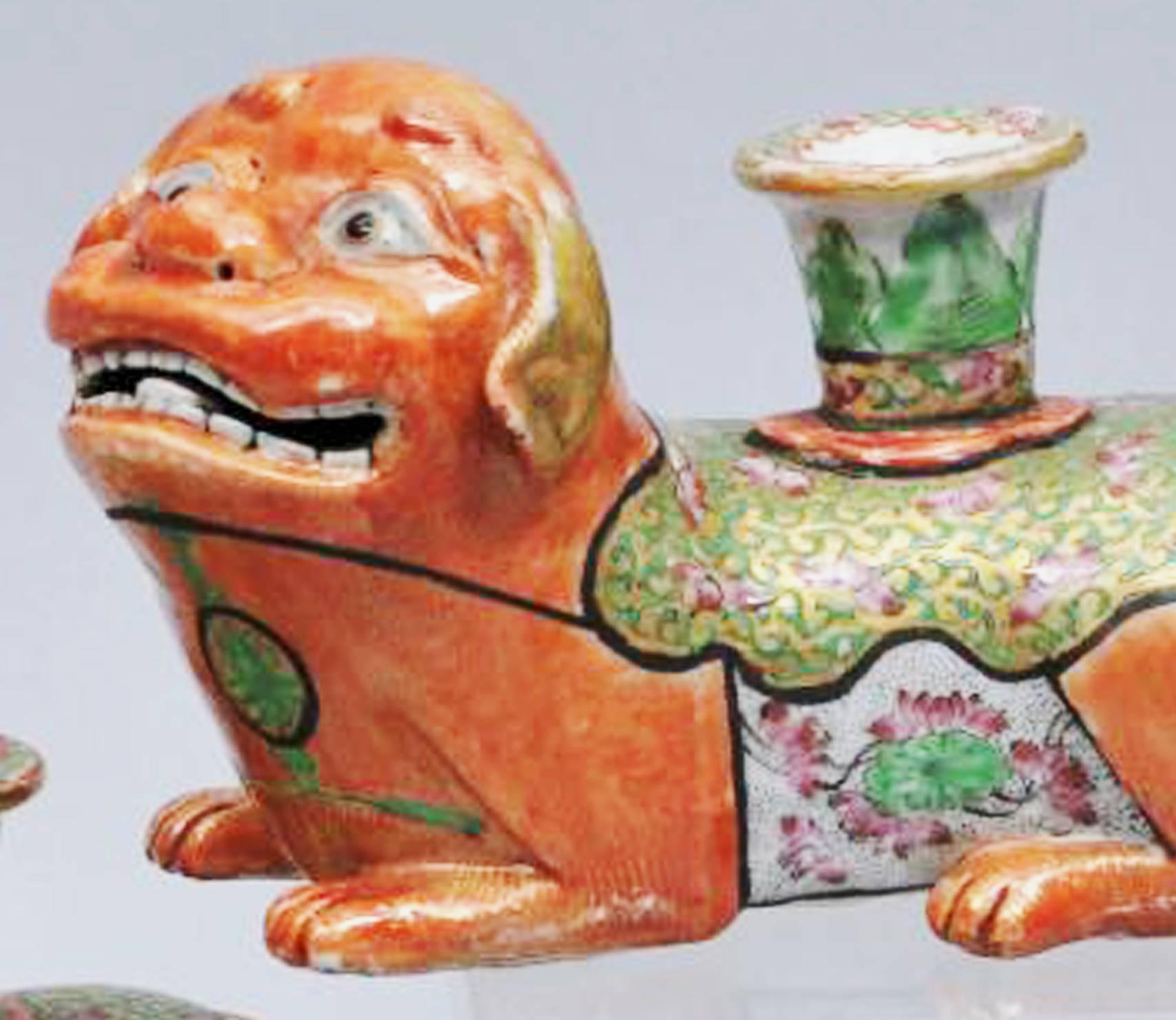 Chinese Export Canton foo dog porcelain candlesticks, 
circa 1840-1860.

Wonderful pair of Chinese Export foo dog candlesticks modelled with the dogs seated on all fours and colored with an orange ground with a short candlestick issuing from