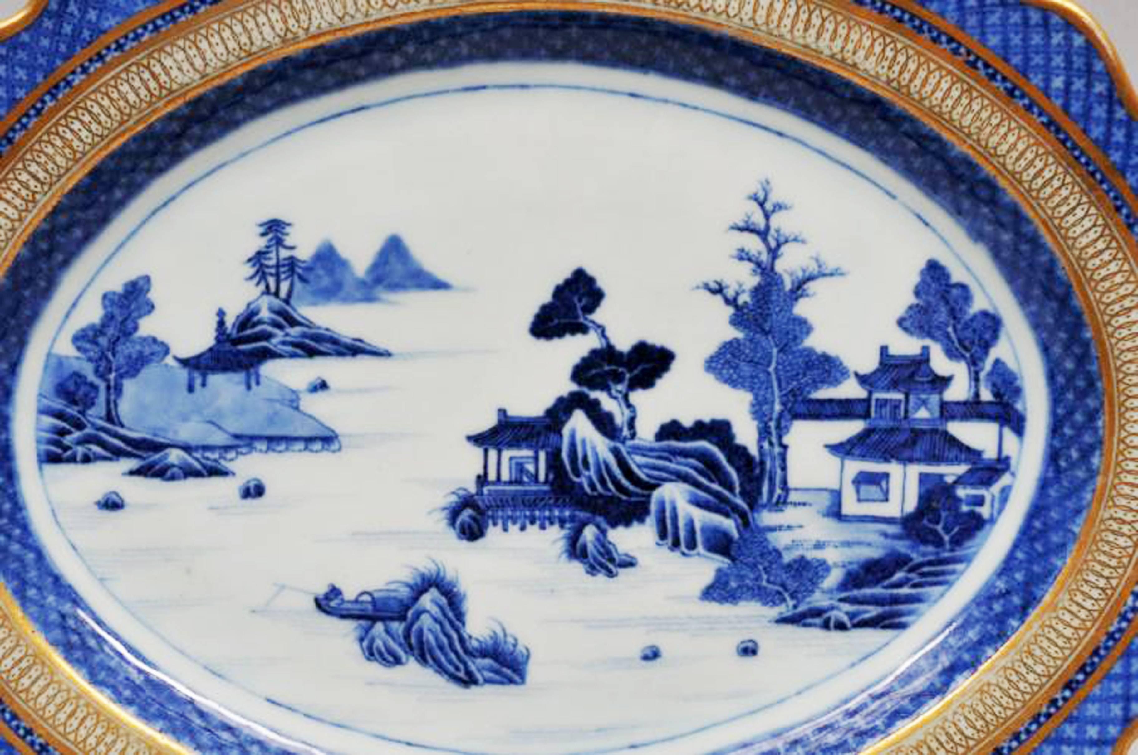 Chinese Export porcelain large underglaze blue and white dish with London-decorated gilt border, 
circa 1780

A large Chinese Export porcelain scalloped-edged dish with a Hills & Stream pattern with a diaper border and gilt decoration applied in