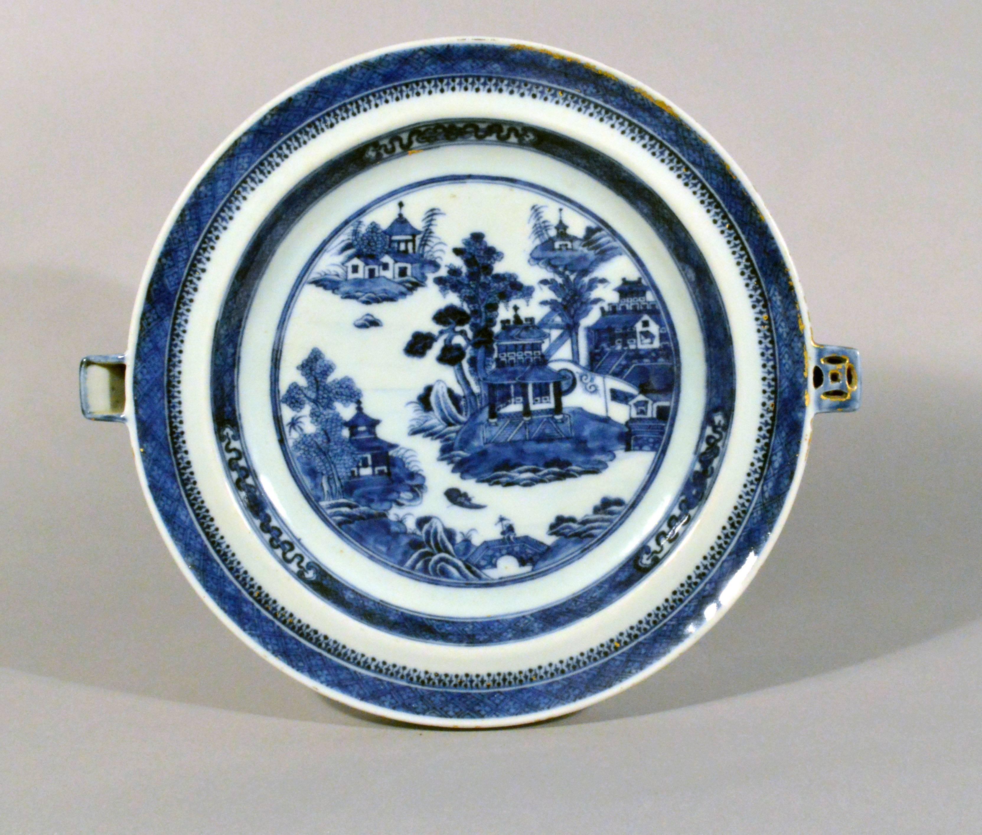 Chinese export blue and white porcelain hot water plates, 
circa 1780-1800.

The Chinese export porcelain underglaze blue and white hot water plates are painted with a riverscape scene with islands and buildings. The border with a diaper band