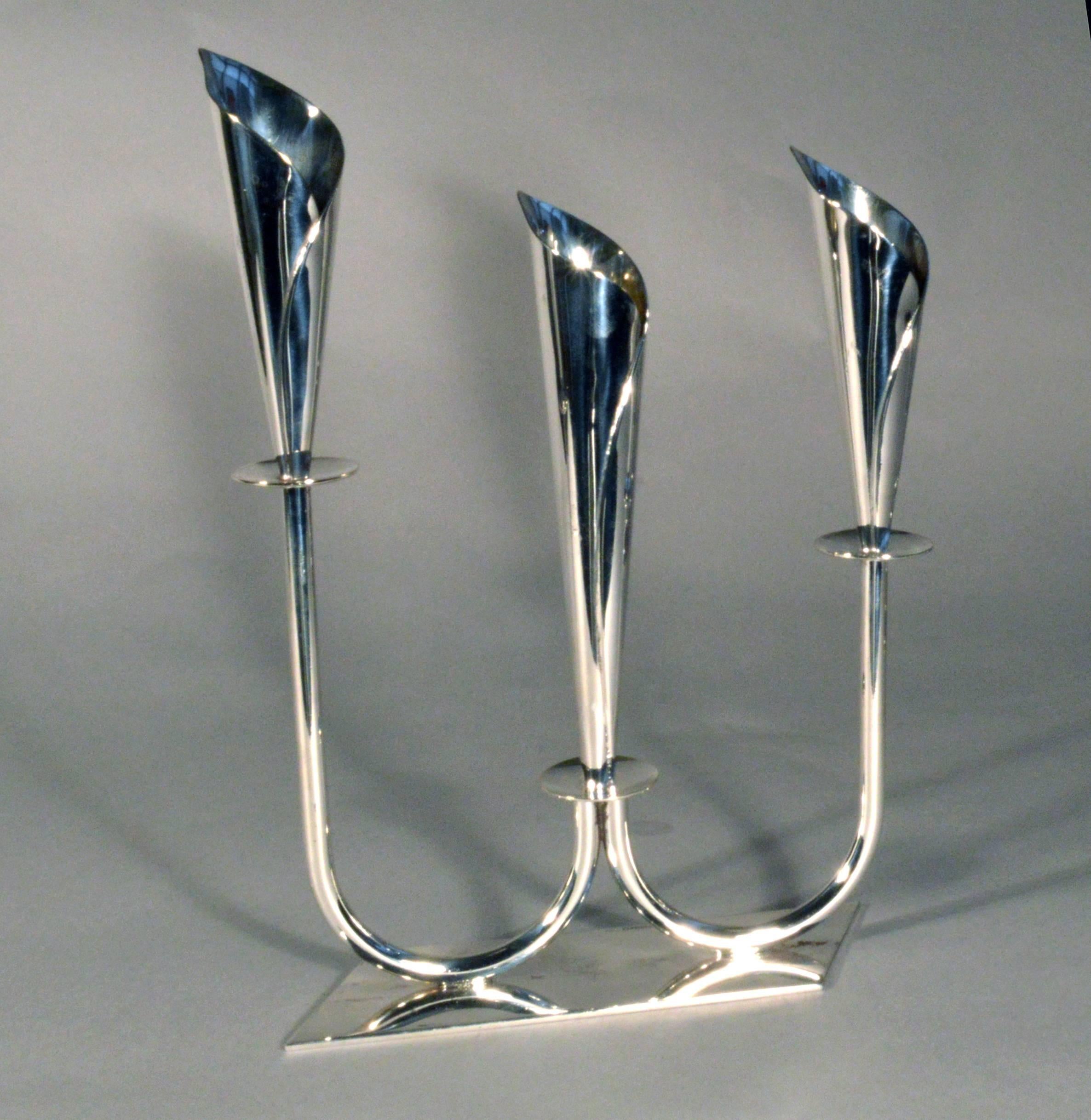 Midcentury Danish silver plate triple candelabra,
Hans Jensen,
1950s.

The candelabra on a shaped, slanted four-sided base have a W-form triple stem, each stem rising to a Calla Lilly sconce with a small drip pan below the