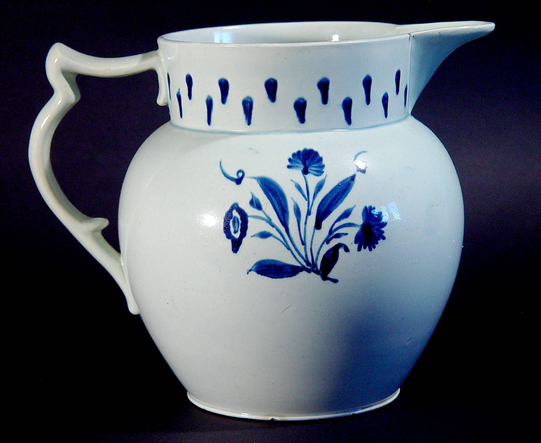 The large underglaze blue and white pearlware jug is decorated with flowers on one side and a simple modernistic stylized drape design on the other.