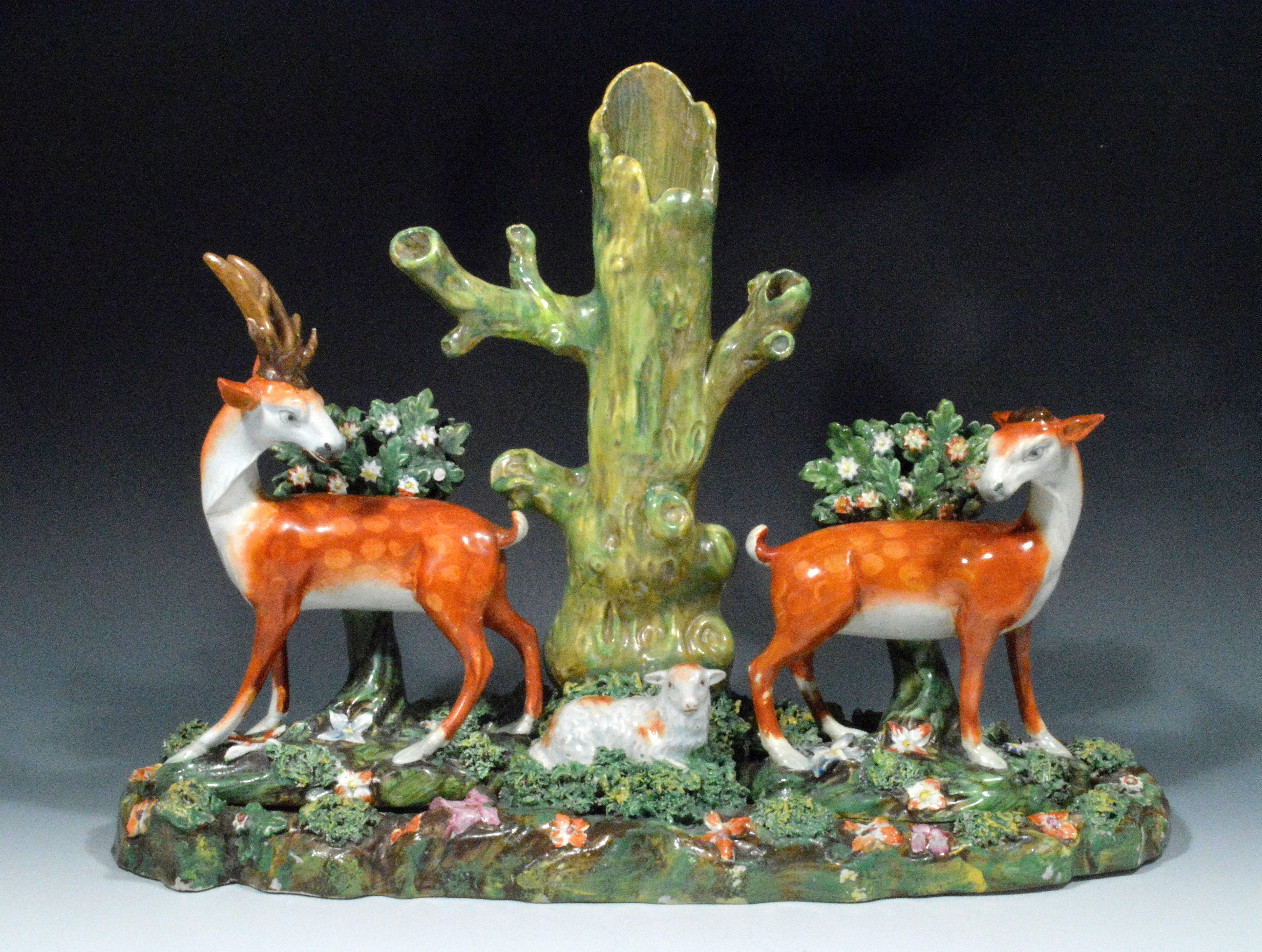 This remarkable and rare Staffordshire pearlware large group is particularly rare with the stag and doe being removable being placed into insets on the oval base. The group depicts two large figures of a stag and doe facing each other either side of