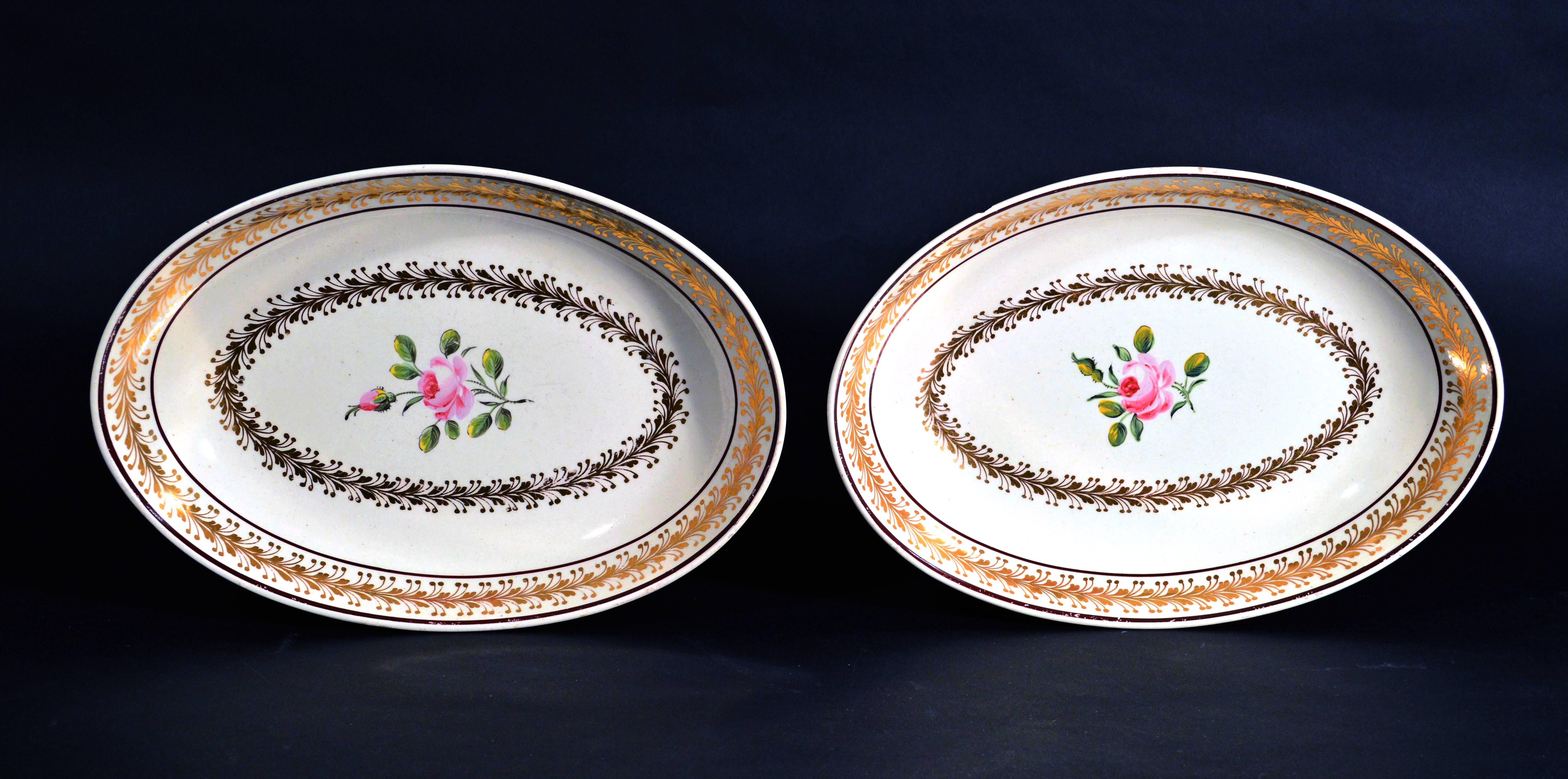 Creamware English pottery pair of botanical 18th-century dishes,
Neale Pottery.

The oval dishes are a rich creamy color painted in the interior with a rose stem with an open rose and a rosebud. 

Around the inner well is a band of finely